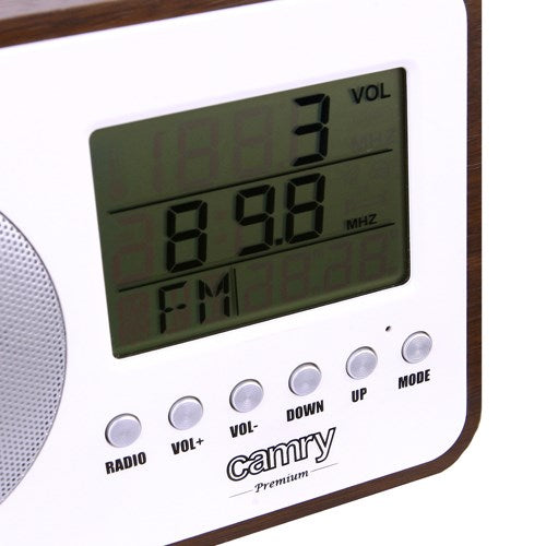 Nahaufnahme eines weiß-holzfarbenen Camry-Radios mit LCD-Bildschirm und silbernen Tasten.