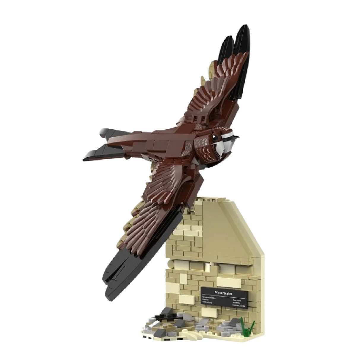 Ein Lego-Modell eines Mauerseglers im Flug auf einem beigen Ziegelwandständer vor weißem Hintergrund.