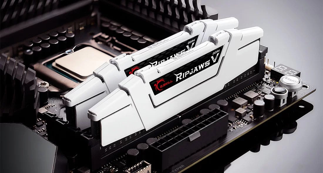 Dwa białe moduły RAM DDR4 G.Skill Ripjaws V są zainstalowane na czarnej płycie głównej.
