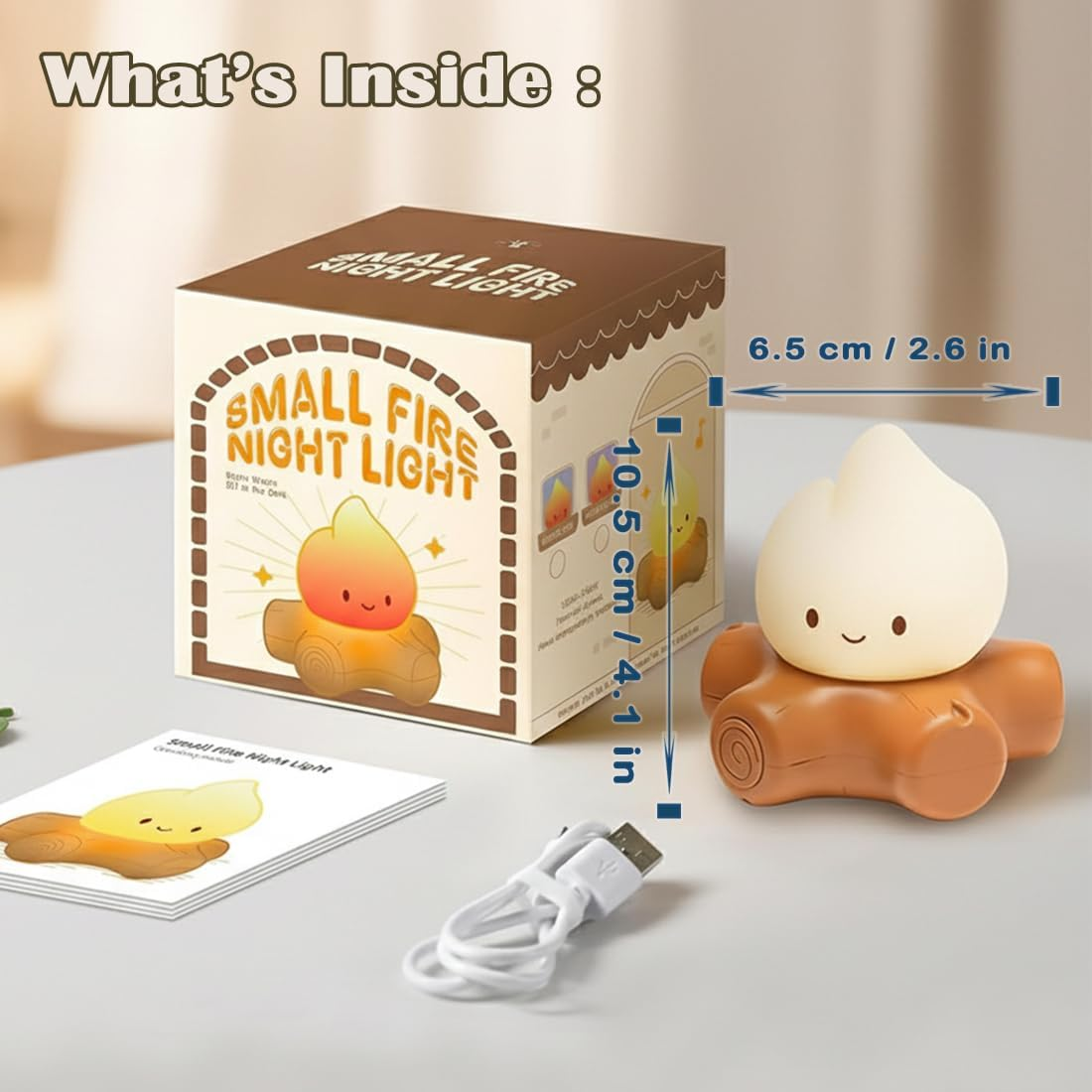 Eine kleine Feuer-Nachtlampe mit Box, USB-Kabel und Anleitung auf dem Tisch.