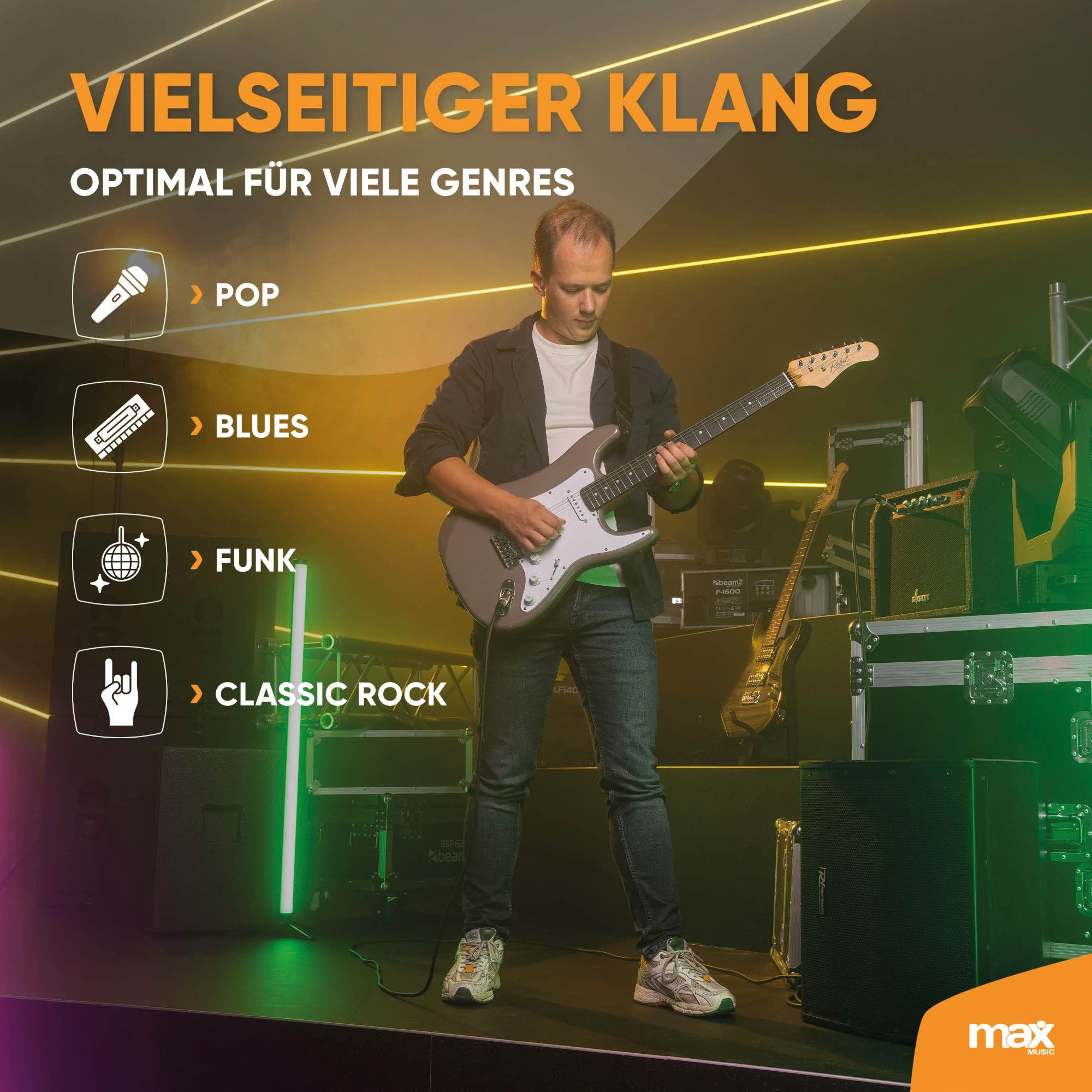 Ein Musiker spielt E-Gitarre auf einer Bühne vor Lautsprechern.