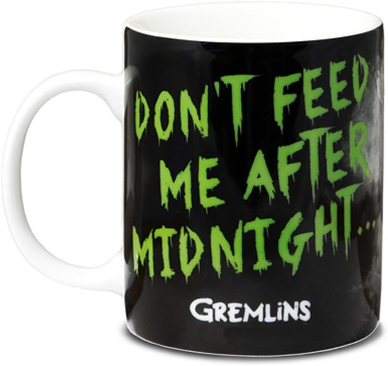 Taza negra con asa blanca y texto verde que dice No me alimentes después de medianoche y logotipo de Gremlins.