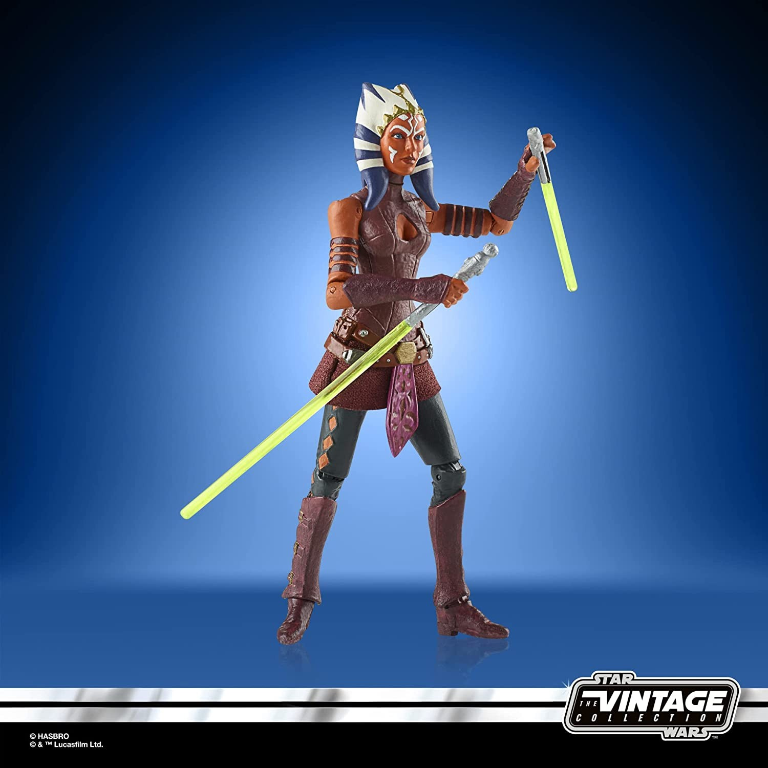 Figurka akcji Ahsoka Tano z dwoma żółtymi mieczami świetlnymi na niebieskim tle.