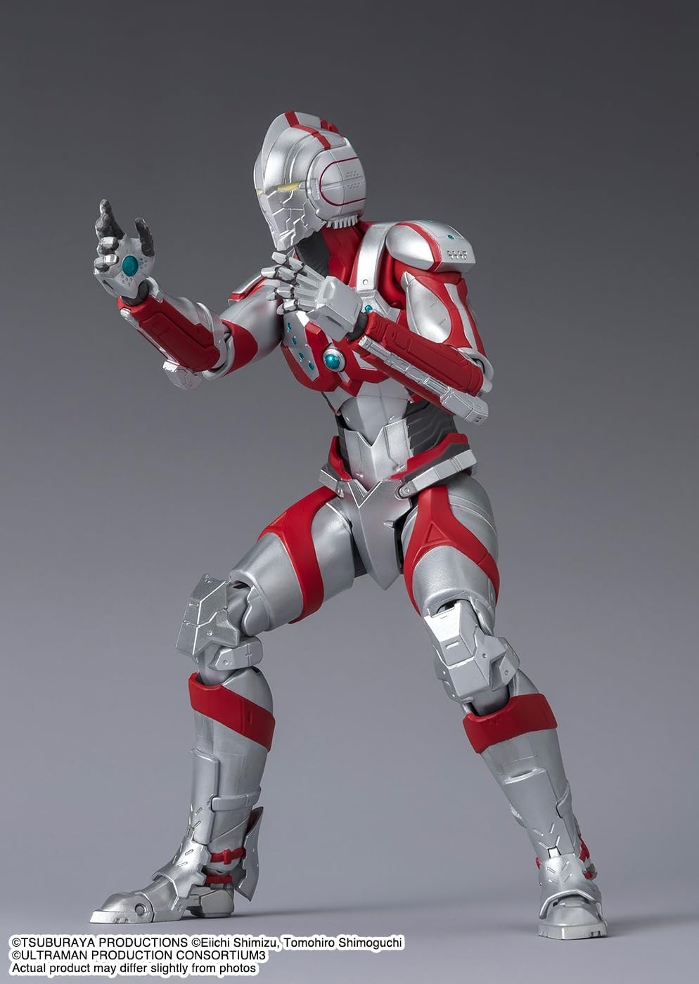 Una figura de acción roja y plateada en postura de combate sobre fondo gris.