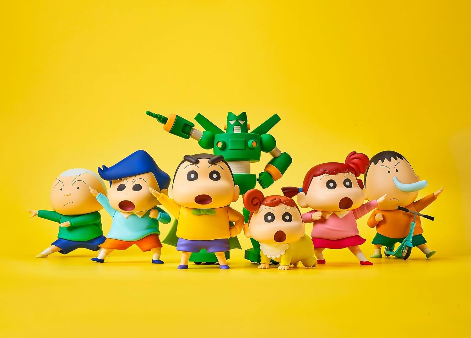 Varias figuras de Crayon Shin-Chan posan junto a un robot verde sobre un fondo amarillo.