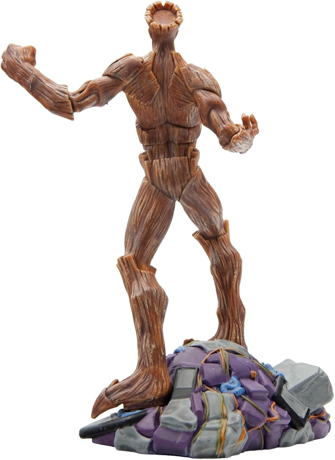 Vista trasera de una figura de acción humanoide de madera marrón sobre una base de escombros morados y grises.