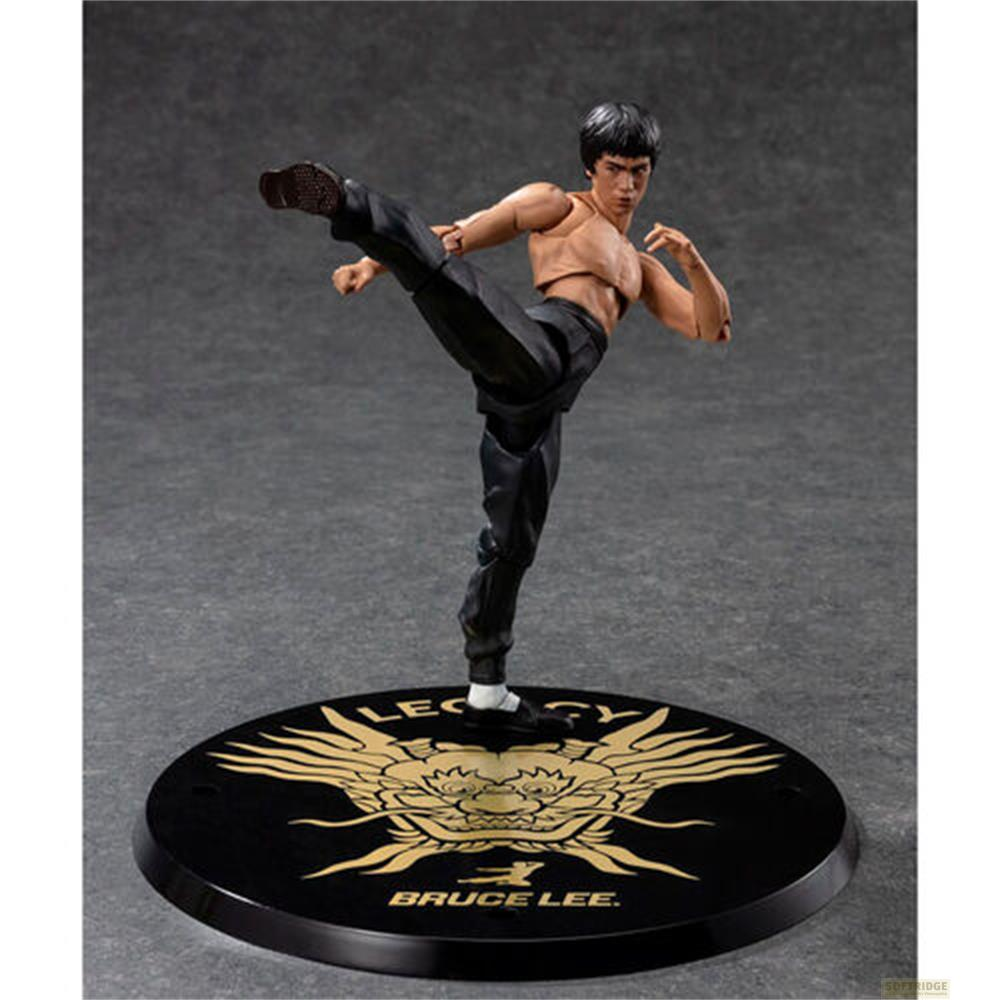 Una figura de acción de Bruce Lee en pose de combate sobre un soporte redondo con fondo gris.
