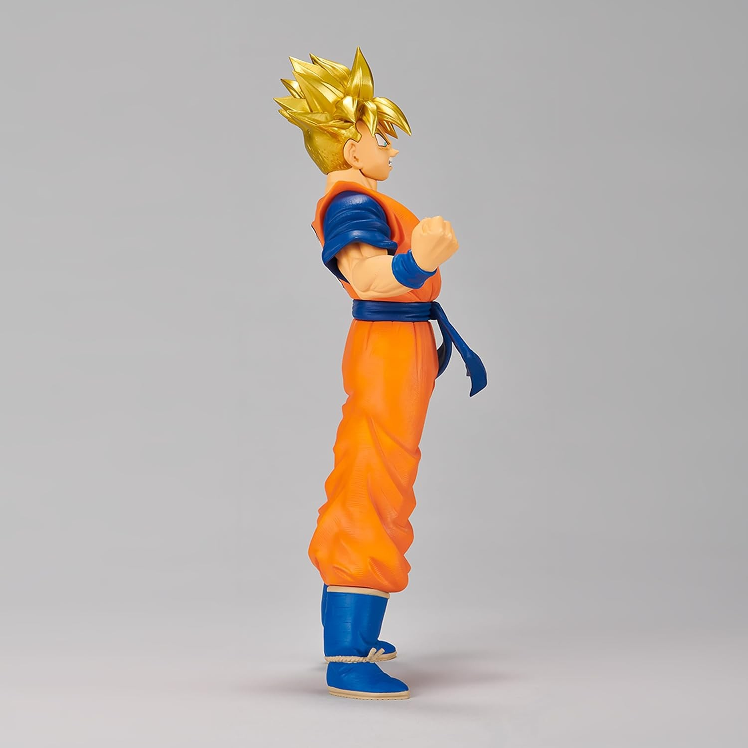 Vista lateral de una figura de acción de Goku con pelo amarillo y traje naranja y azul.