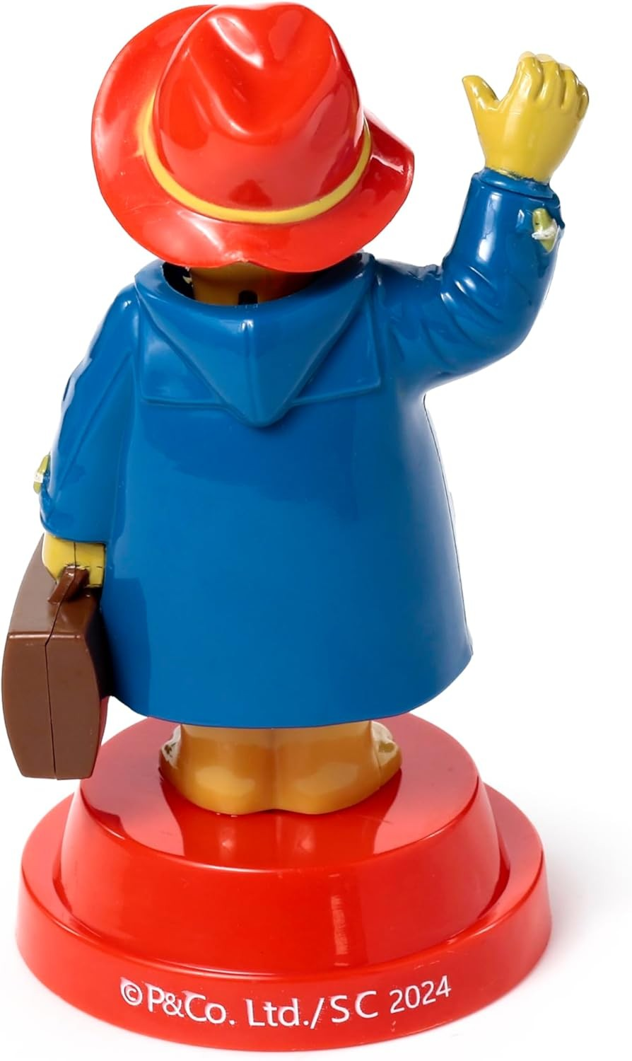 Vista trasera de una figura de Paddington con abrigo azul y sombrero rojo en base roja.