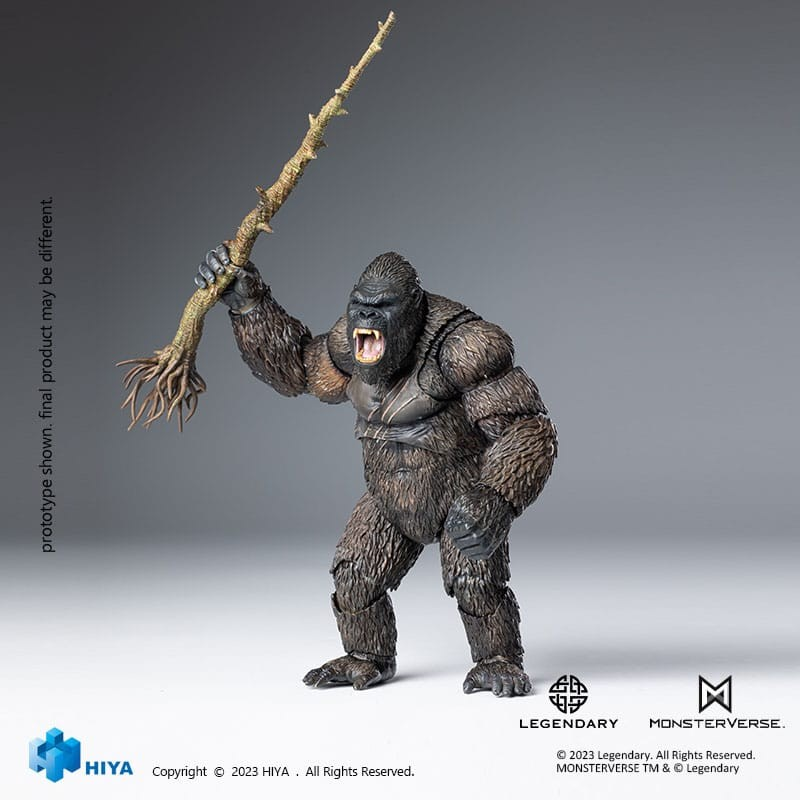 Una figura de acción de King Kong ruge mientras sostiene una rama de árbol grande sobre un fondo gris.