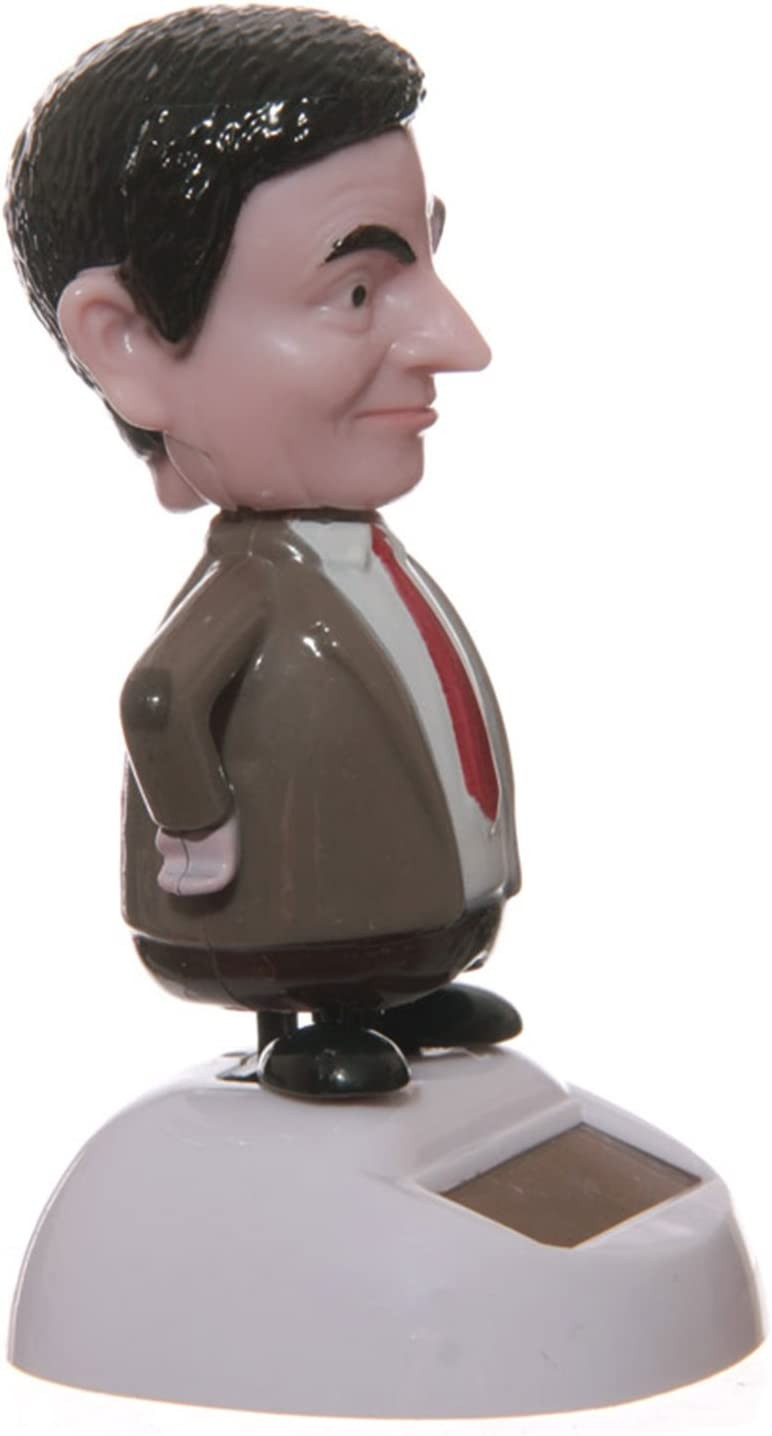 Figura cabezona de Mr. Bean con traje marrón y corbata roja sobre base blanca con panel solar.