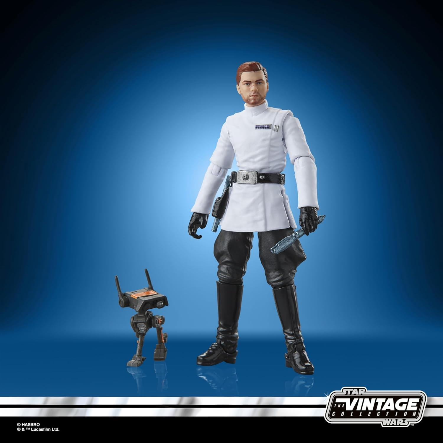 Figura de acción de un hombre con uniforme blanco junto a un droide en un fondo azul.