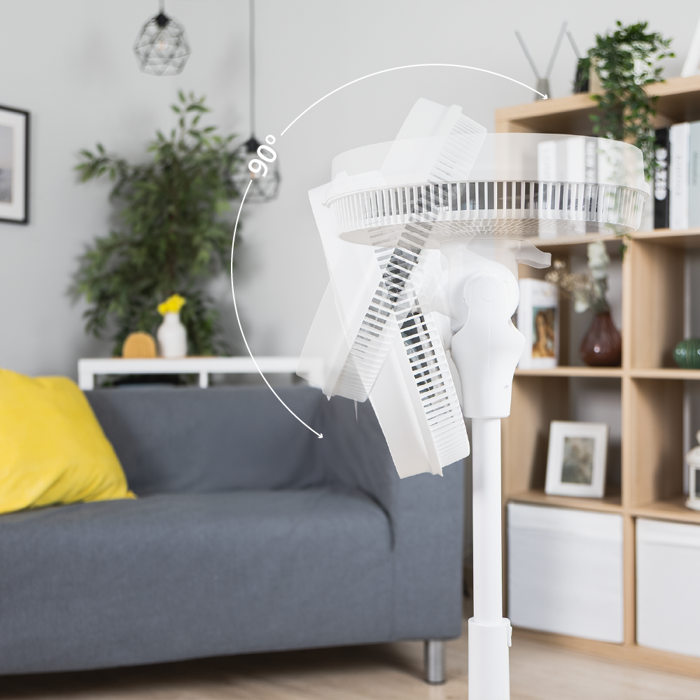 Ventilador de pie blanco en una sala con giro de 90 grados.