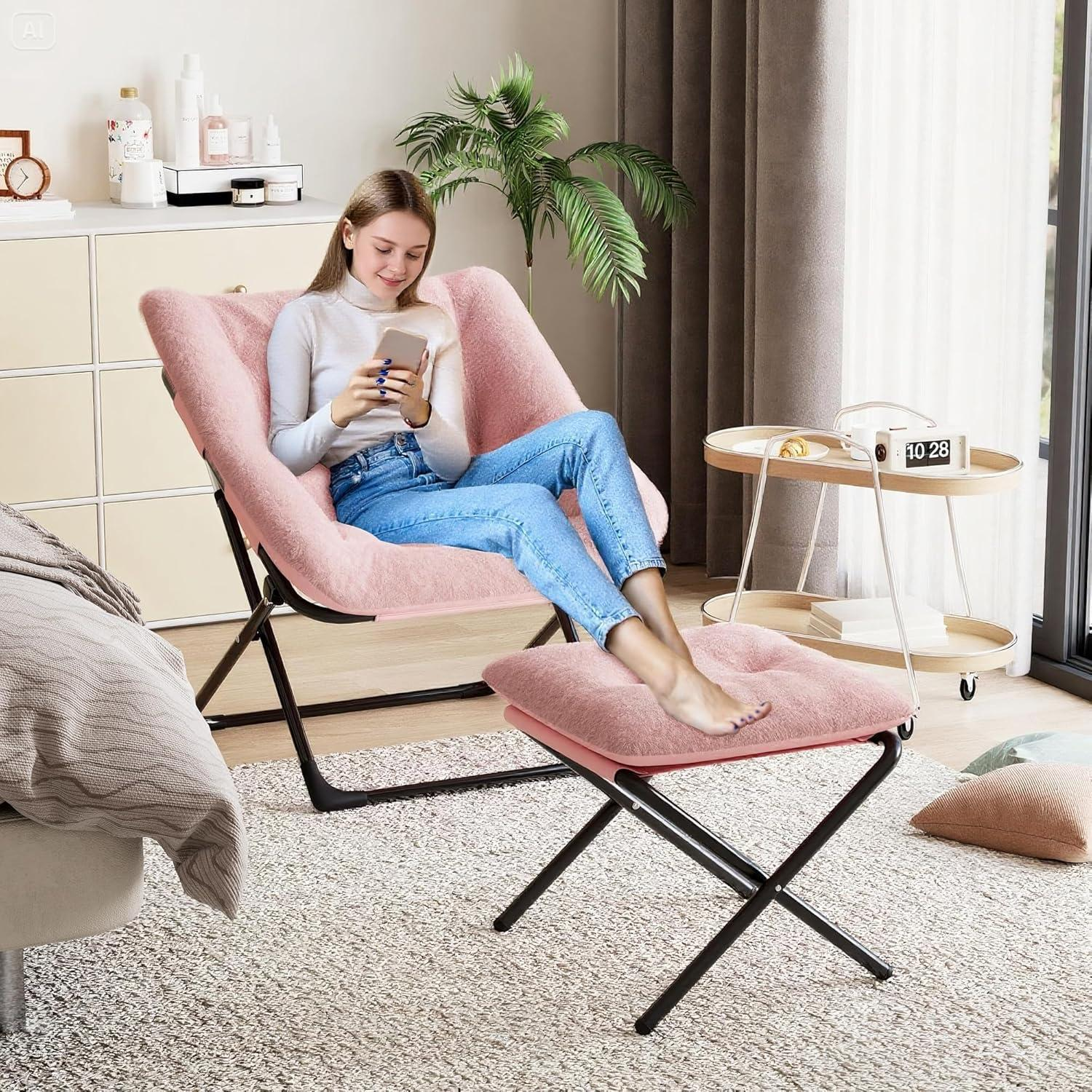 Una donna sorridente con jeans e maglione bianco siede su una poltrona rosa soffice, usando uno smartphone.