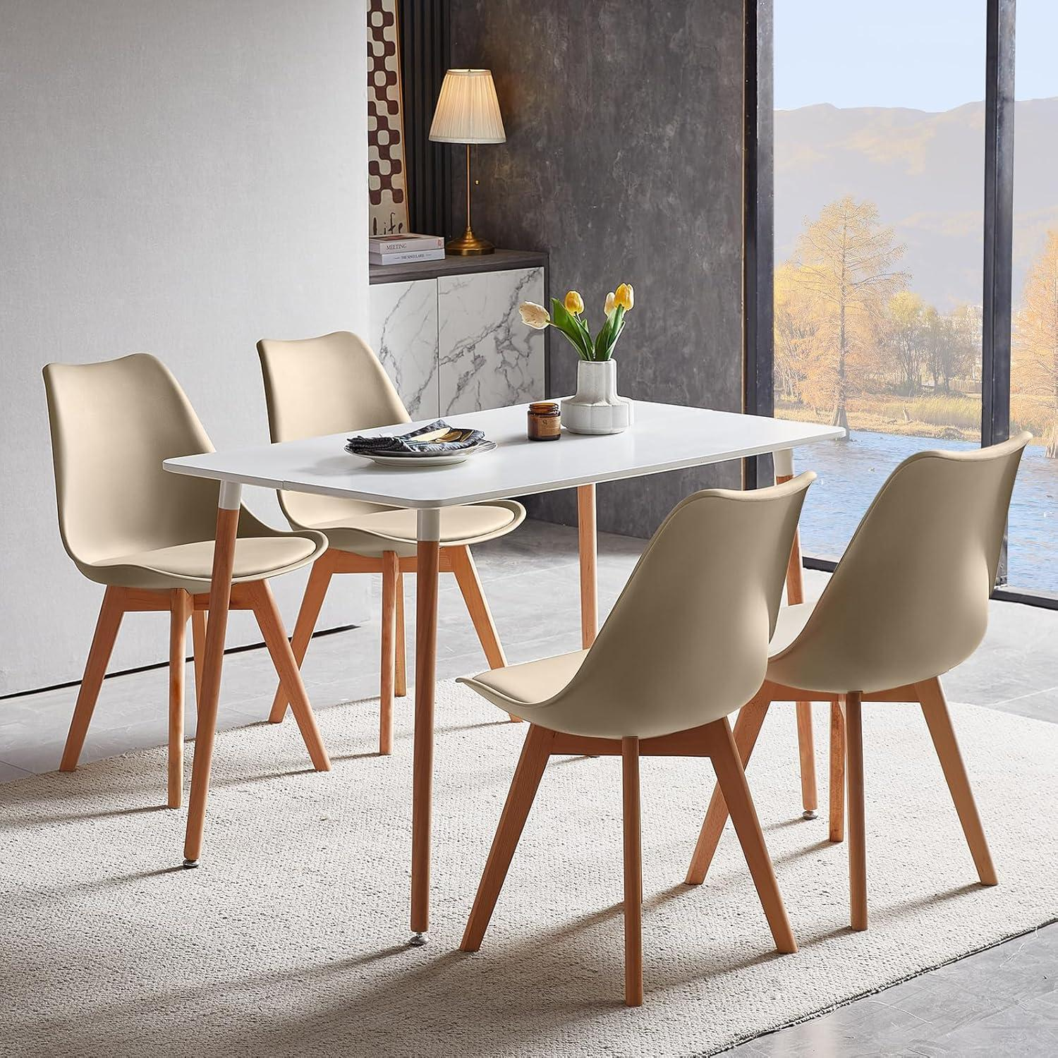 Moderno tavolo da pranzo bianco con quattro sedie beige su un tappeto in una stanza.