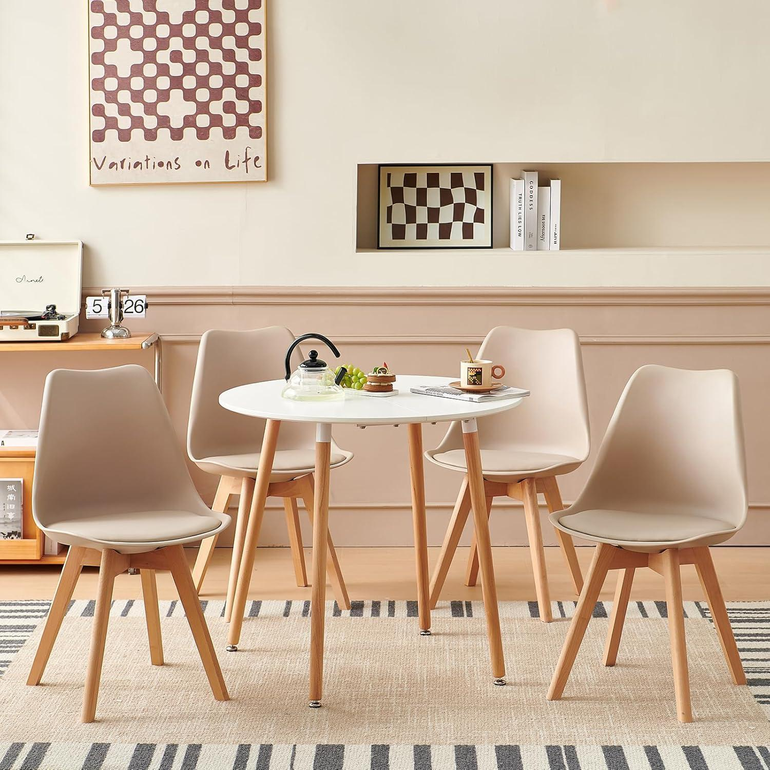Un tavolo da pranzo rotondo bianco con quattro sedie beige su un tappeto.