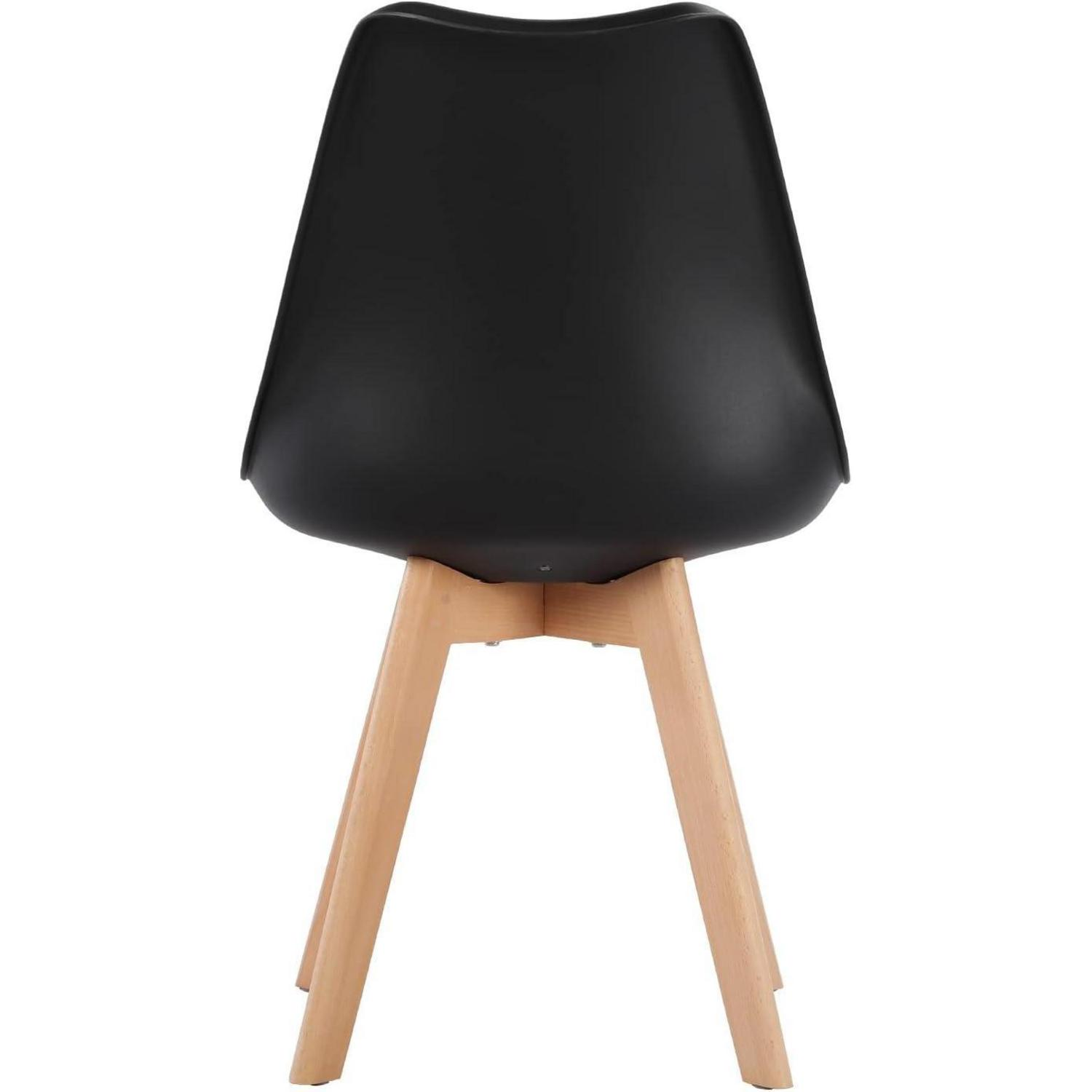 Una sedia nera con gambe in legno su sfondo bianco.