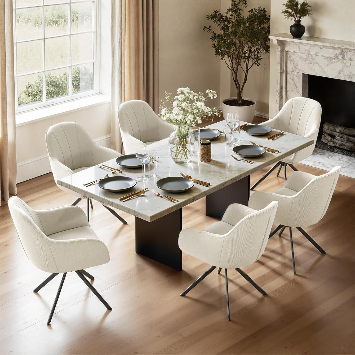 Sala da pranzo con tavolo in marmo bianco, sei poltroncine beige e vaso.