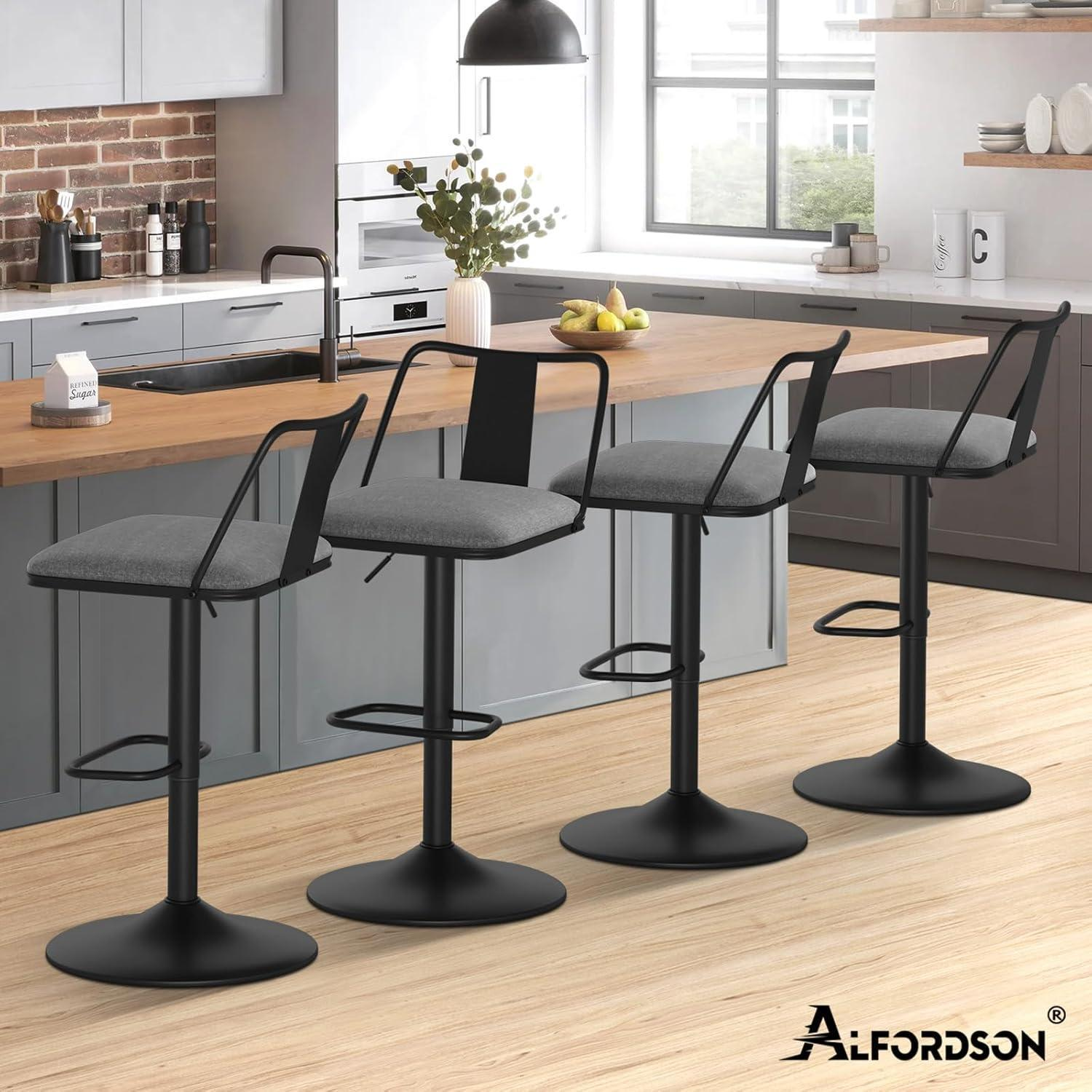 Quattro moderni sgabelli da bar con sedute grigie e strutture in metallo nero in una cucina luminosa.