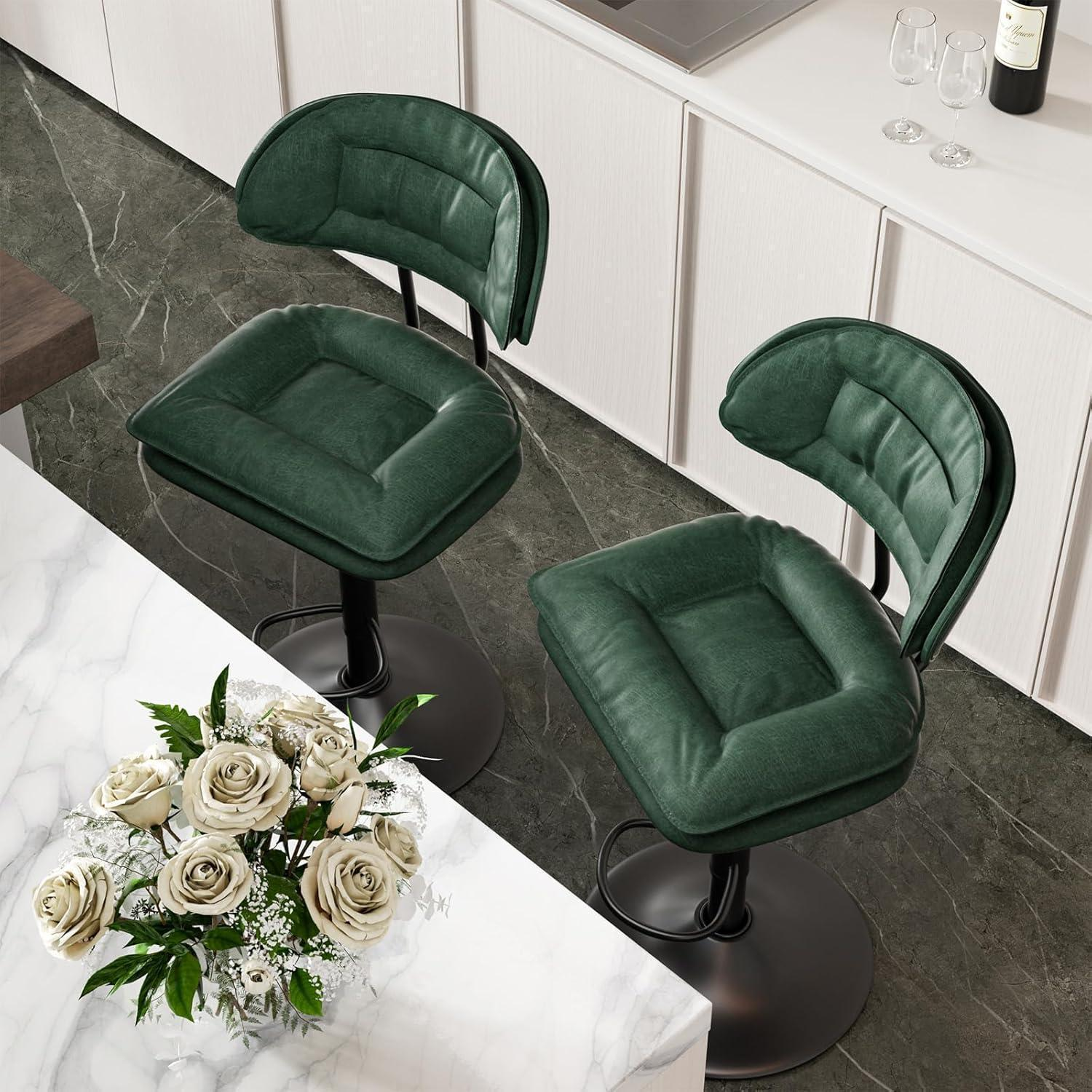 Due sgabelli da bar verdi con sedute e schienali imbottiti su un pavimento in marmo grigio davanti a un bancone bianco.