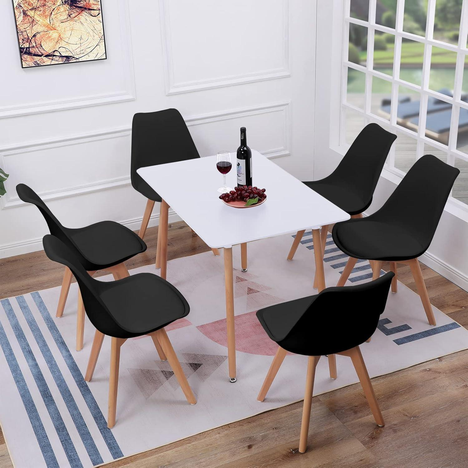 Un tavolo da pranzo bianco con sei sedie nere e gambe in legno si trova su un tappeto in una stanza luminosa.
