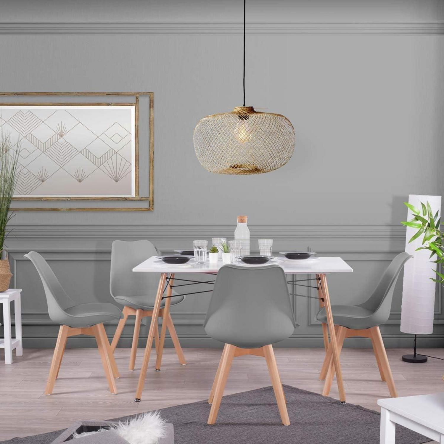 Sala da pranzo moderna con tavolo bianco, quattro sedie grigie, dettagli in legno e lampada.