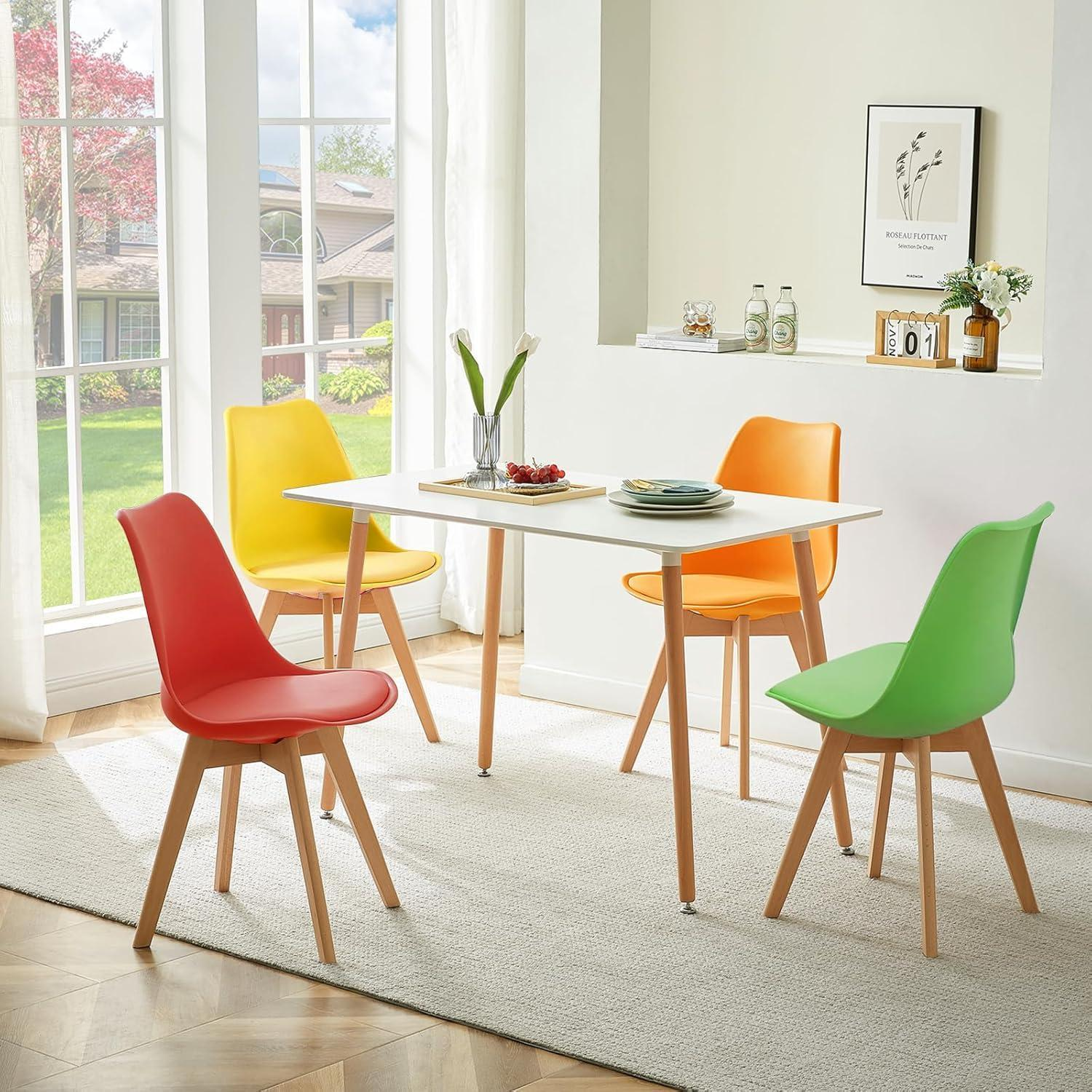 Un tavolo da pranzo bianco con sedie colorate rosse, gialle, arancioni e verdi su un tappeto.