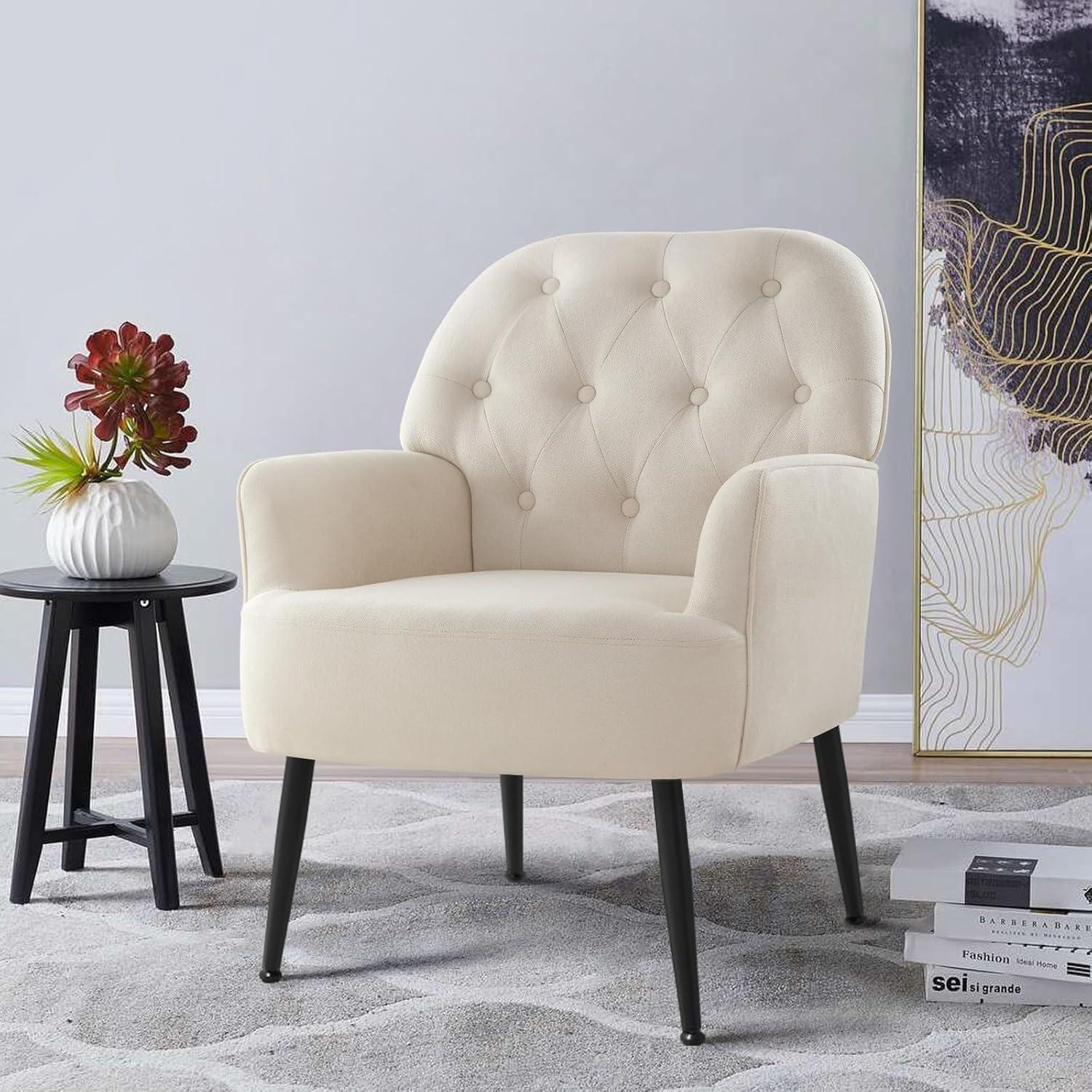 Poltrona beige con gambe nere su tappeto fantasia vicino a un tavolino e un'opera d'arte.