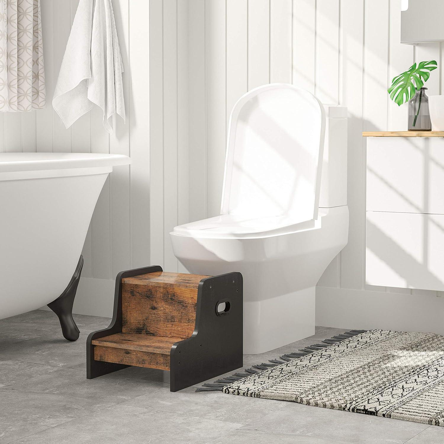 Uno sgabello di legno a due gradini si trova davanti a un WC bianco in un bagno luminoso.