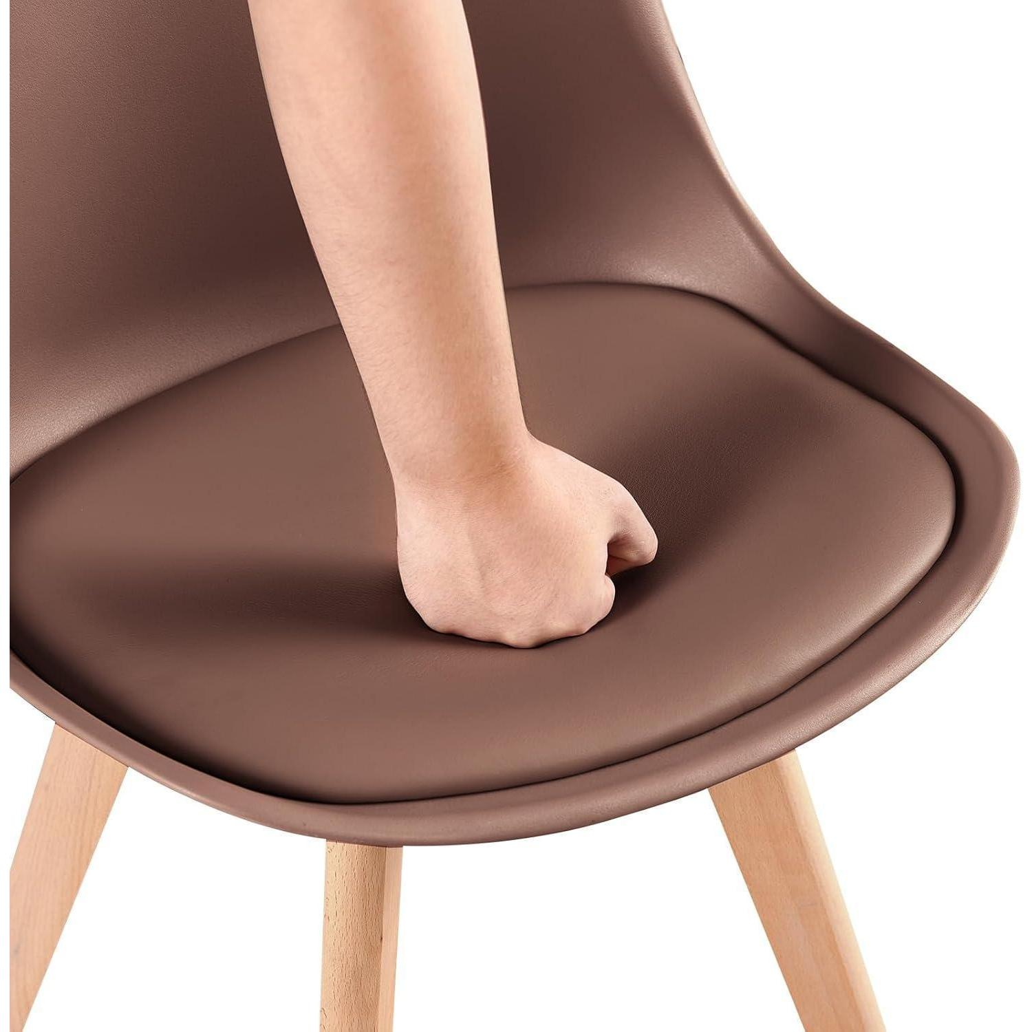 Un pugno preme sul morbido cuscino di una sedia marrone con gambe in legno.