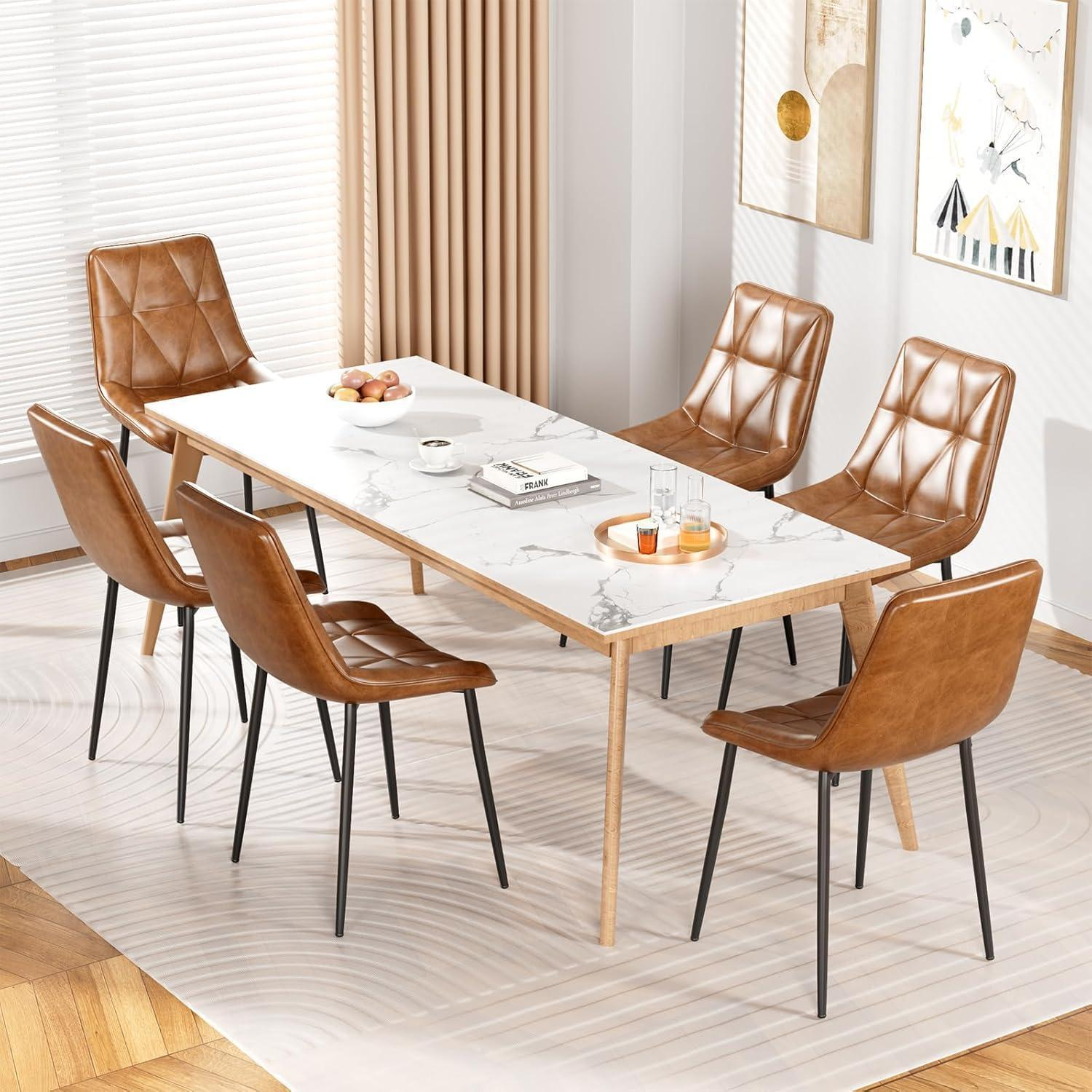 Un tavolo da pranzo in marmo bianco con sei sedie in pelle marrone su un tappeto a motivi in una stanza luminosa.