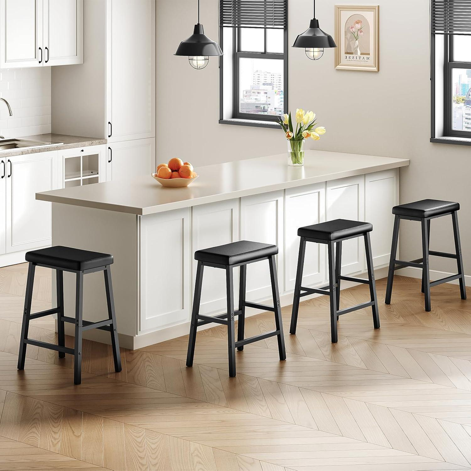 Cucina moderna con una lunga isola bianca, quattro sgabelli neri e pavimento in legno a spina di pesce.