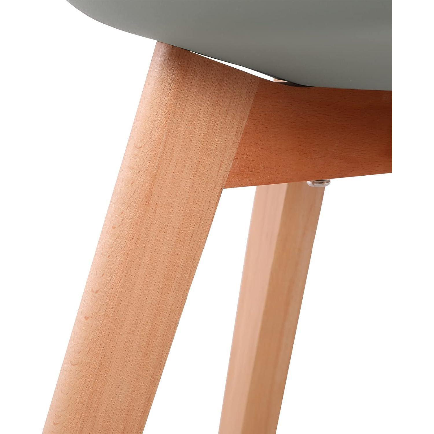 Primo piano delle gambe in legno chiaro e del collegamento della seduta di una sedia moderna su sfondo bianco.