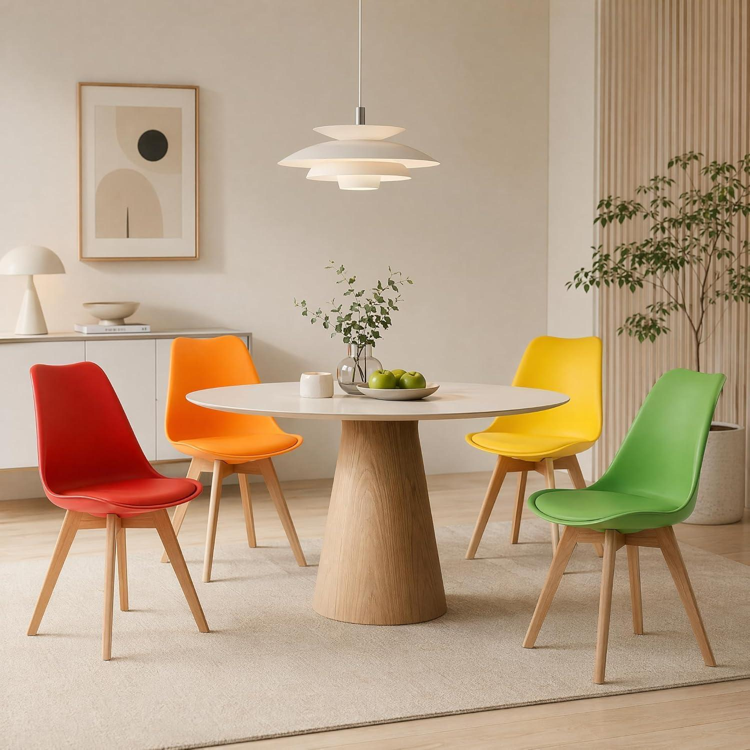 Una sala da pranzo luminosa con un tavolo rotondo in legno e quattro sedie colorate in rosso, arancione, giallo e verde.