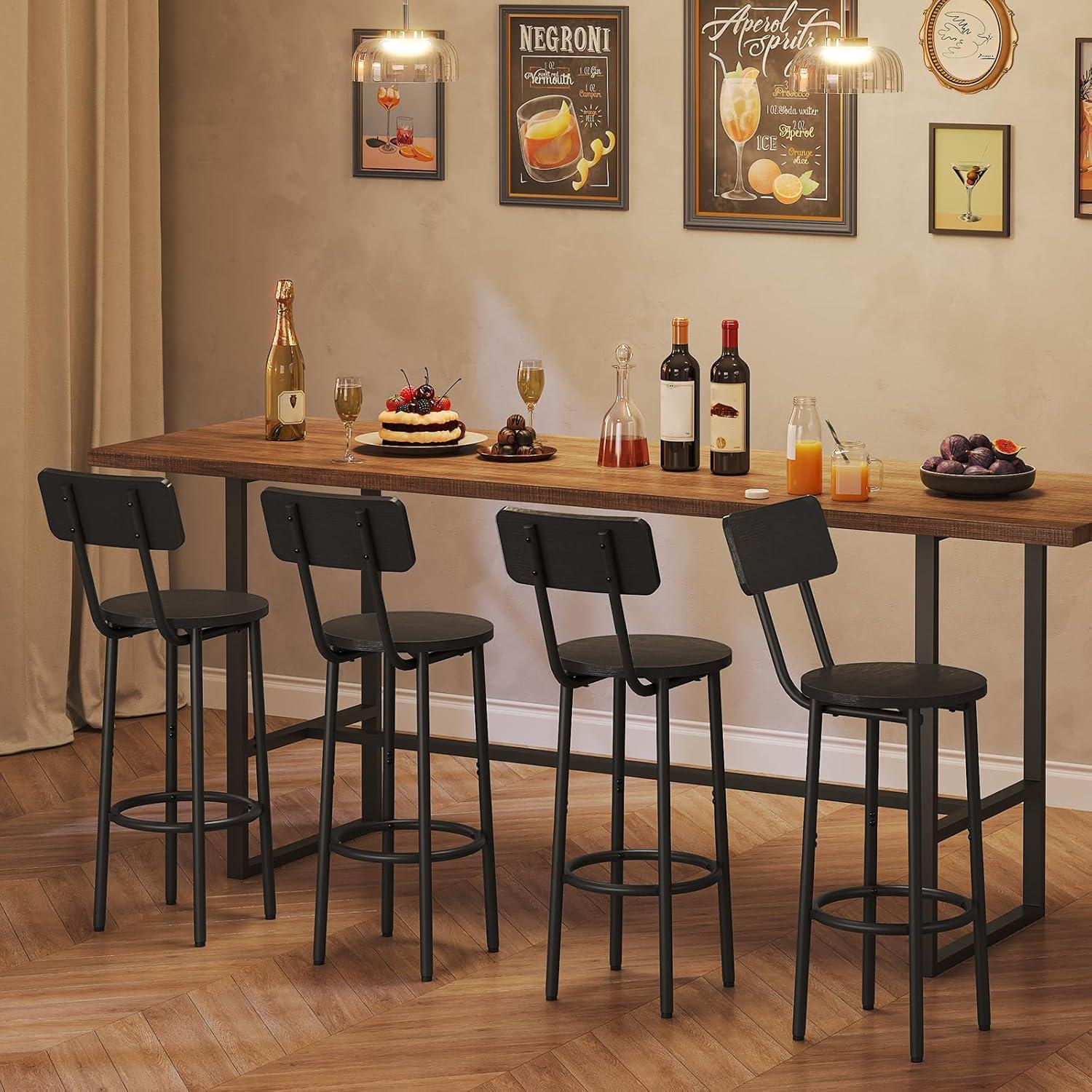 Un lungo tavolo in legno con quattro sgabelli da bar neri, bevande e dolci davanti a una parete beige con poster.