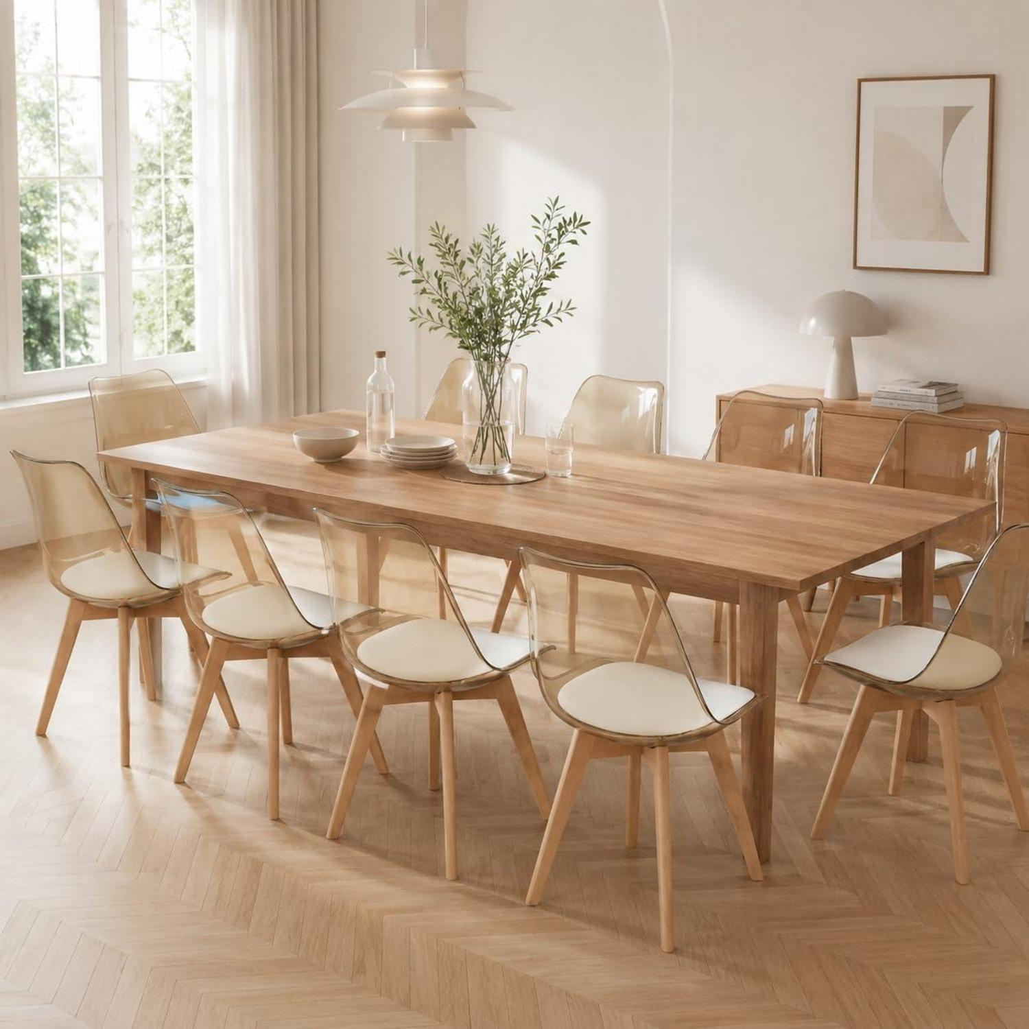 Un lungo tavolo da pranzo in legno con sedie trasparenti in una stanza luminosa e moderna.