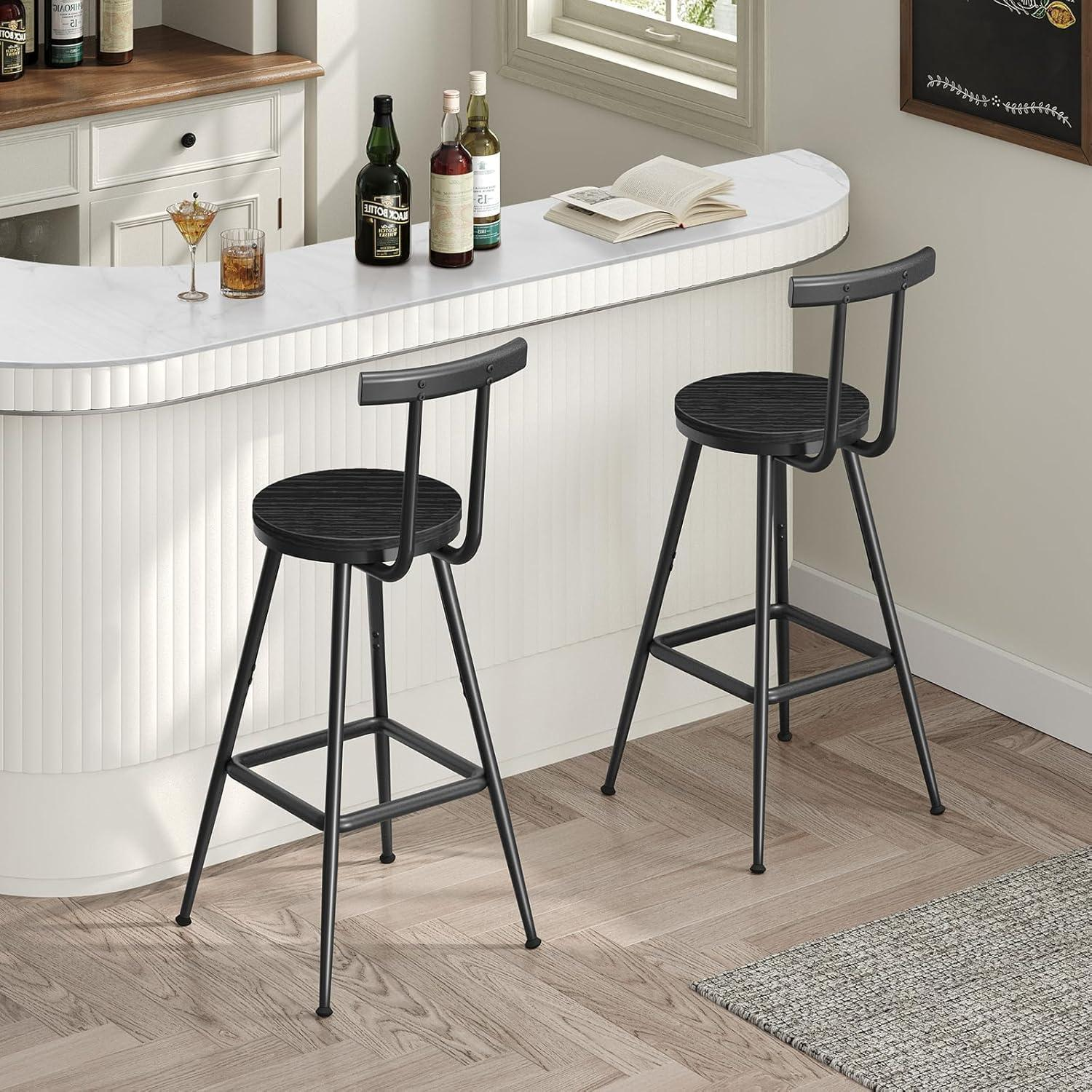 Due sgabelli da bar in metallo nero con sedute in legno rotonde in una cucina luminosa con bancone in marmo e bottiglie.