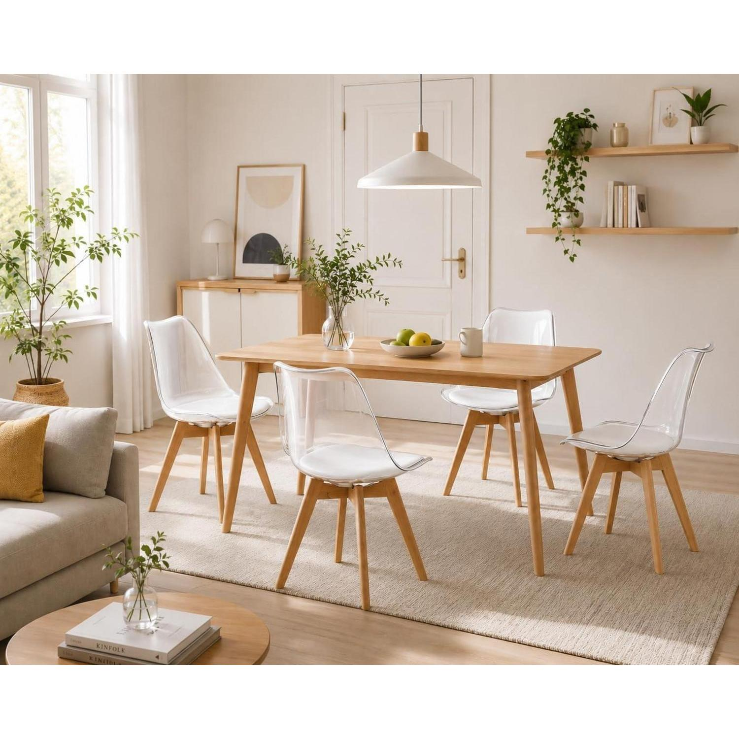 Una luminosa zona pranzo con tavolo in legno e quattro sedie trasparenti su un tappeto.