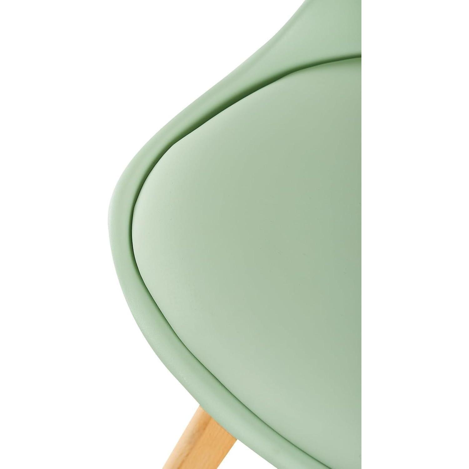 Primo piano della seduta di una sedia verde menta con gambe in legno su sfondo bianco.