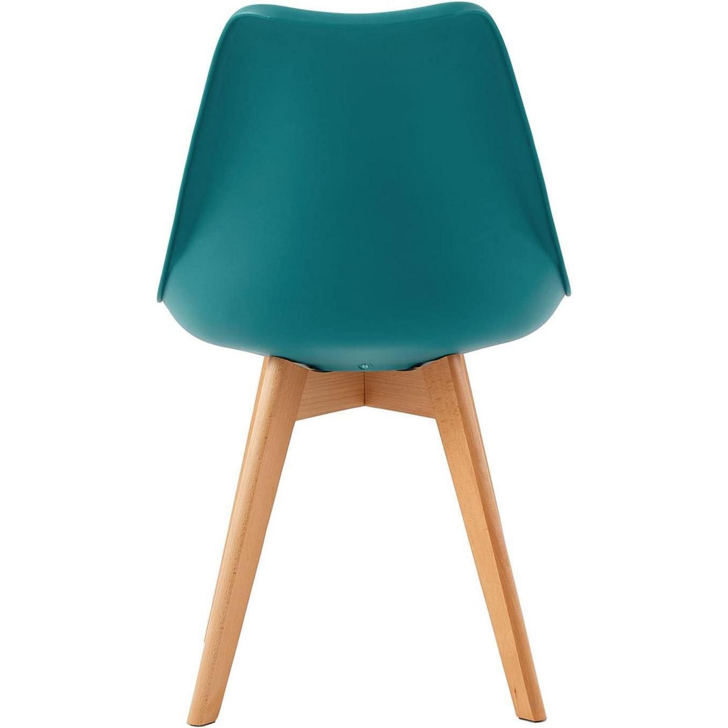 Vista posteriore di una sedia turchese con gambe in legno su sfondo bianco.