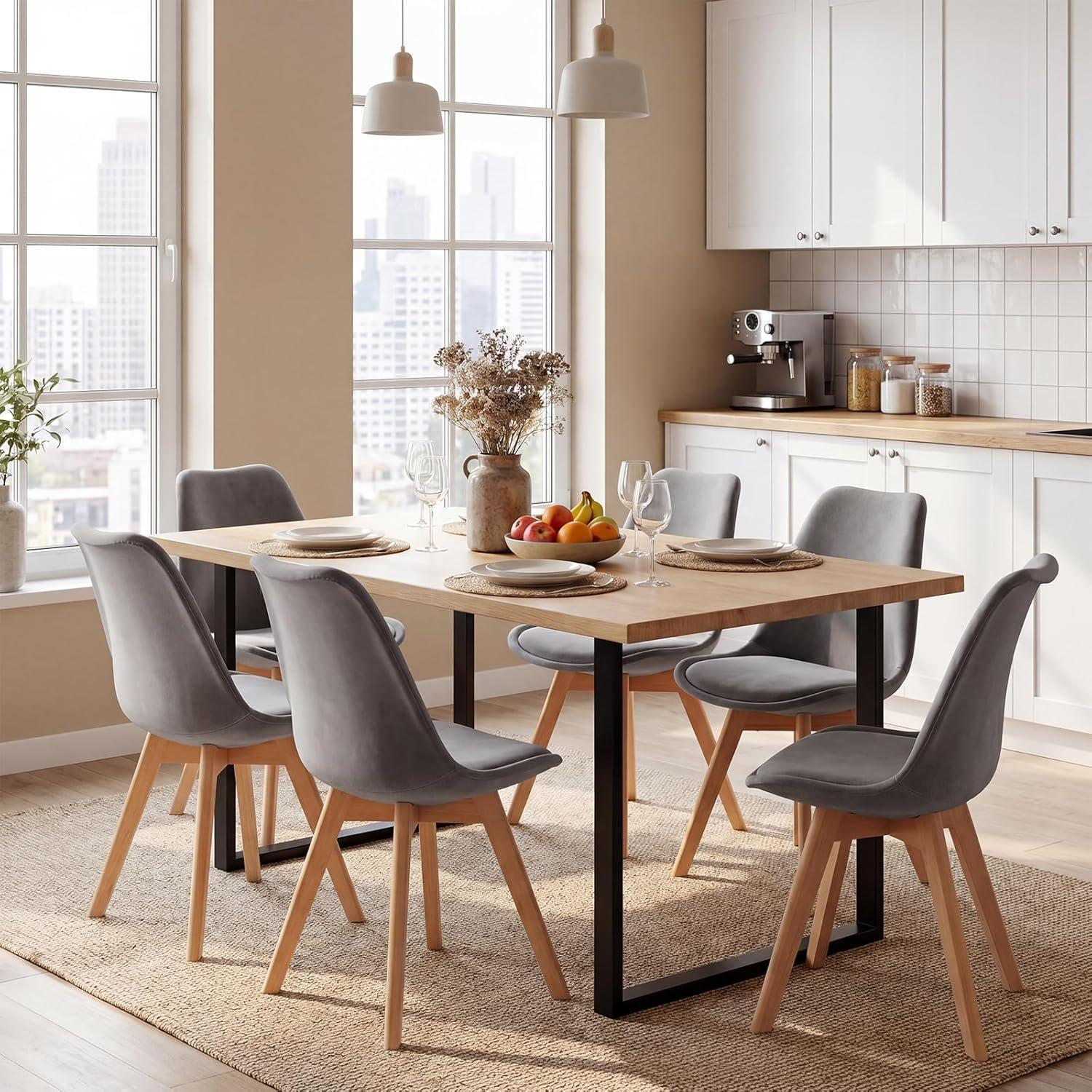 Un tavolo da pranzo in legno con sei sedie grigie e frutta in una cucina moderna e luminosa con vista.