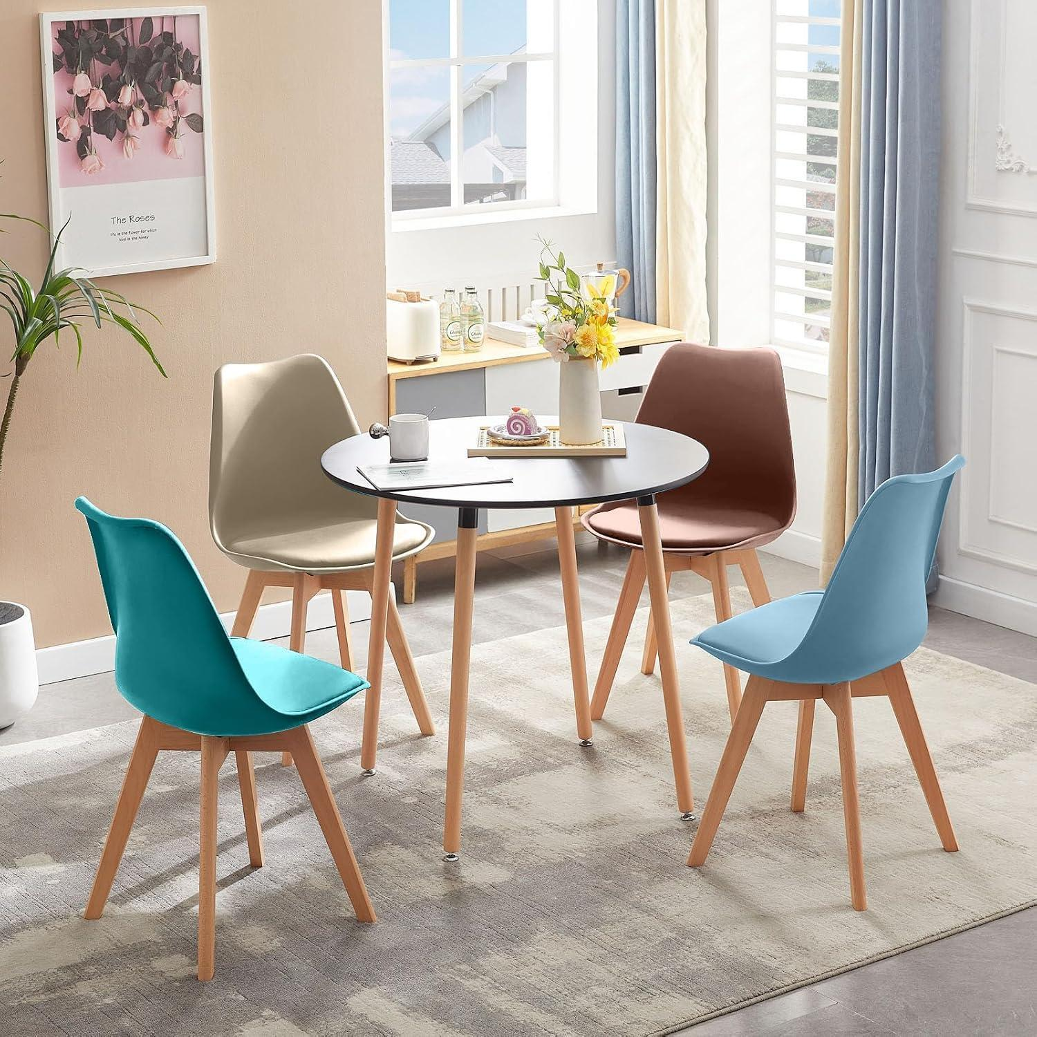 Un tavolo rotondo nero con gambe in legno è circondato da quattro sedie colorate in blu, turchese, marrone e beige.