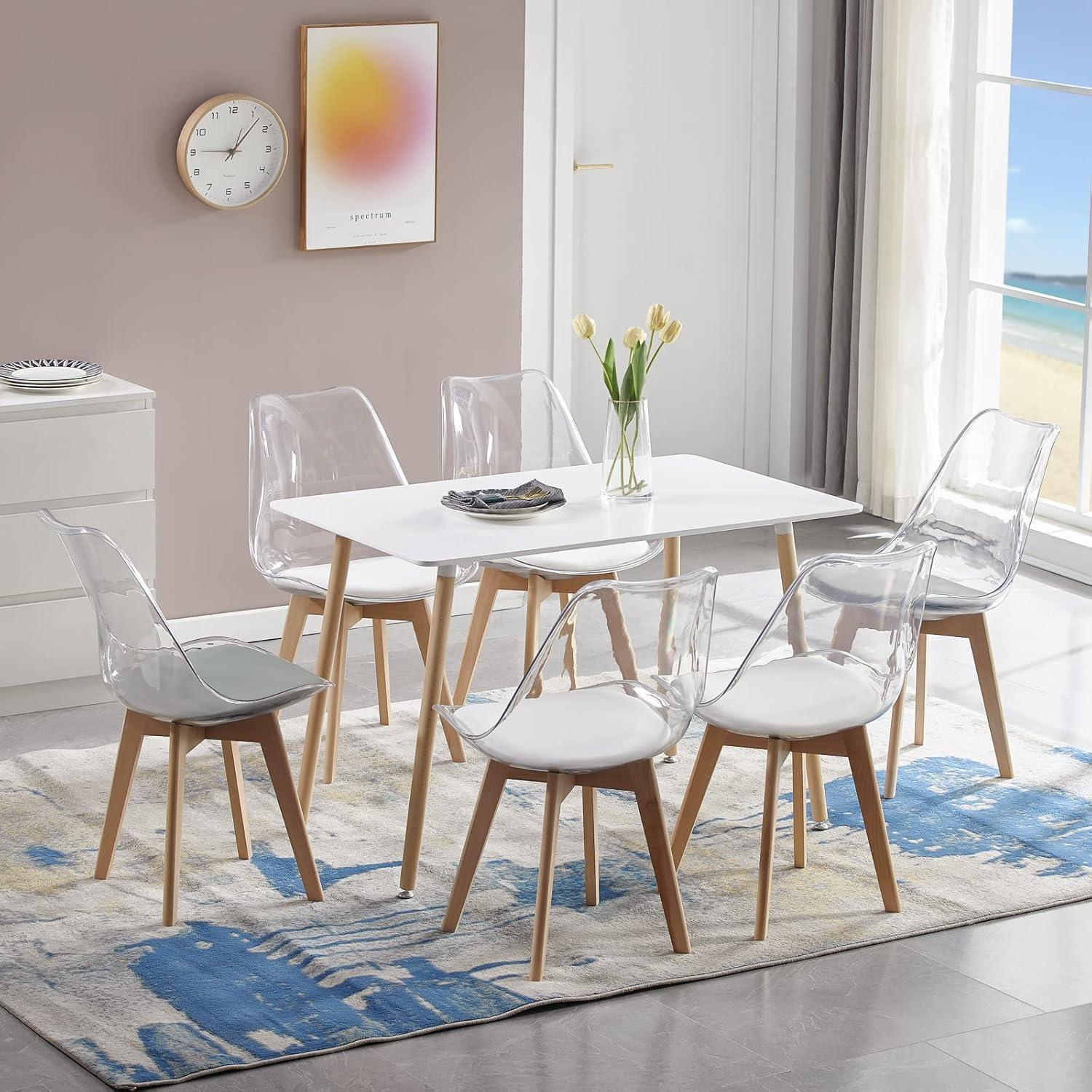 Moderno tavolo da pranzo bianco con sei sedie trasparenti e gambe in legno su un tappeto blu e grigio.