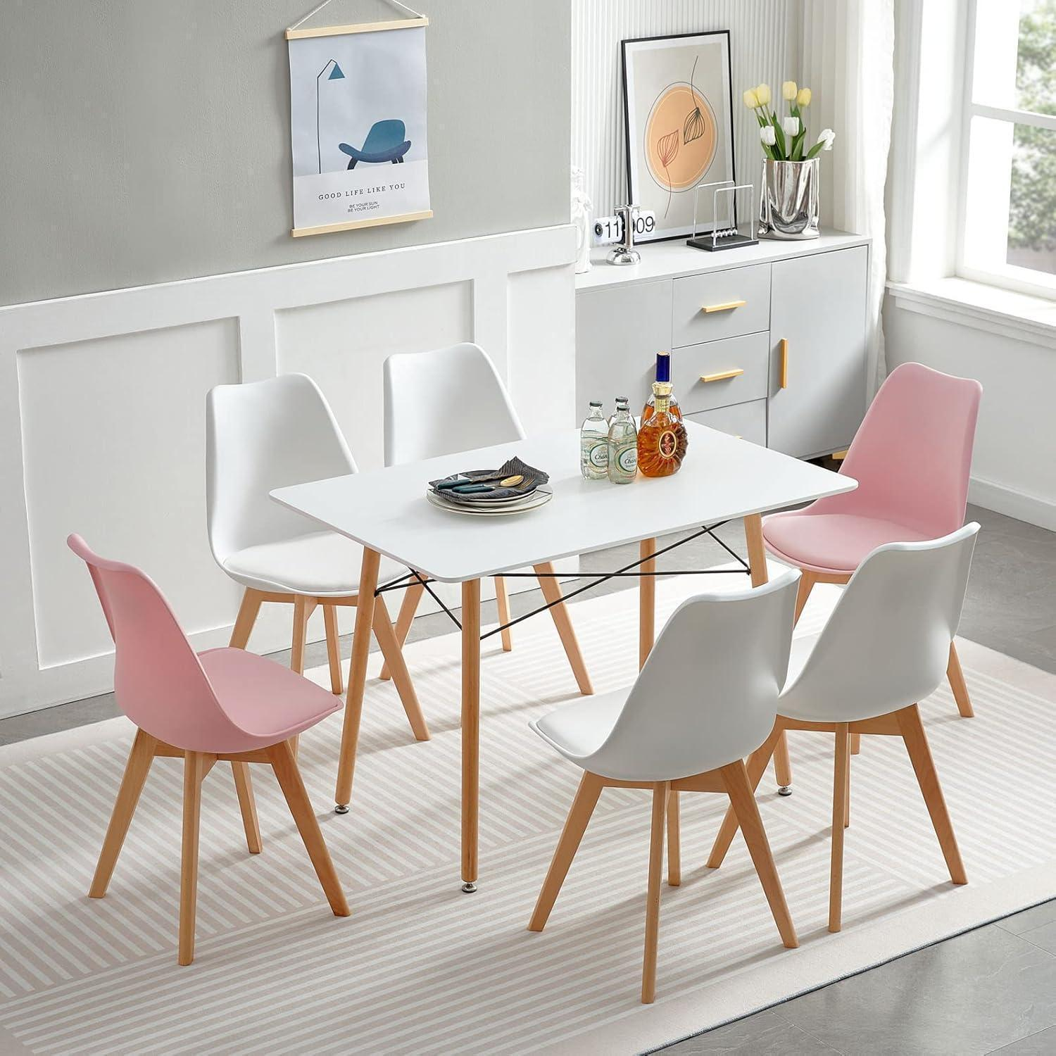 Moderno tavolo da pranzo bianco con sei sedie bianche e rosa su un tappeto a righe.