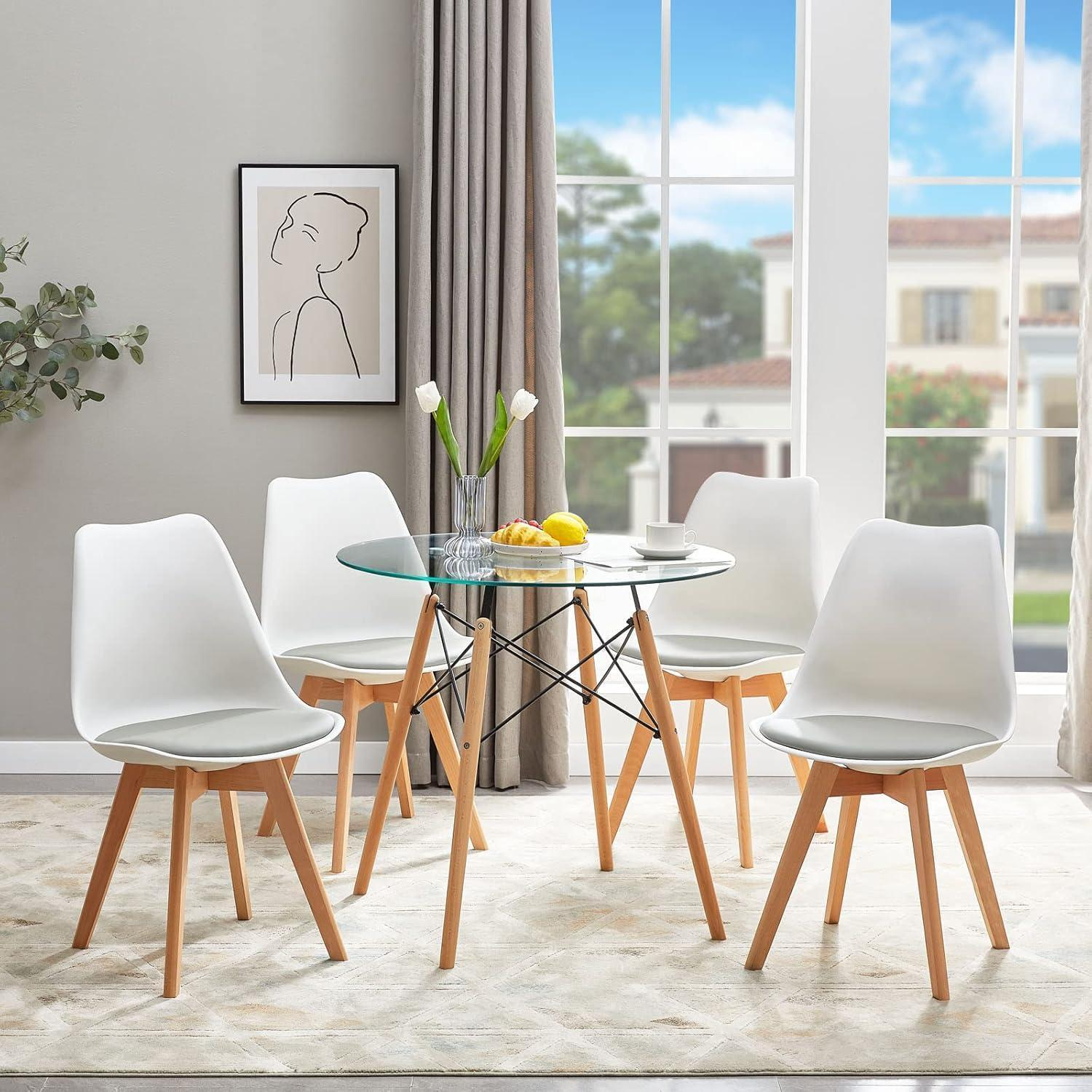 Tavolo da pranzo in vetro con gambe in legno e quattro sedie bianche luminose.