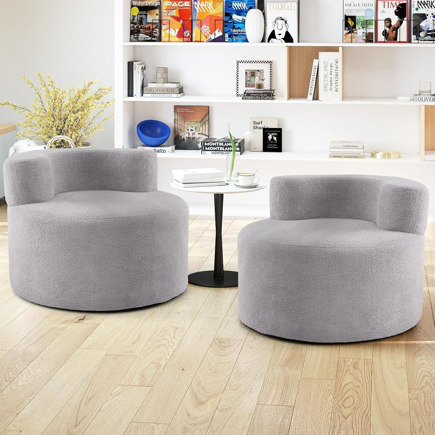 Due poltrone in peluche grigio davanti a uno scaffale bianco in una stanza luminosa.