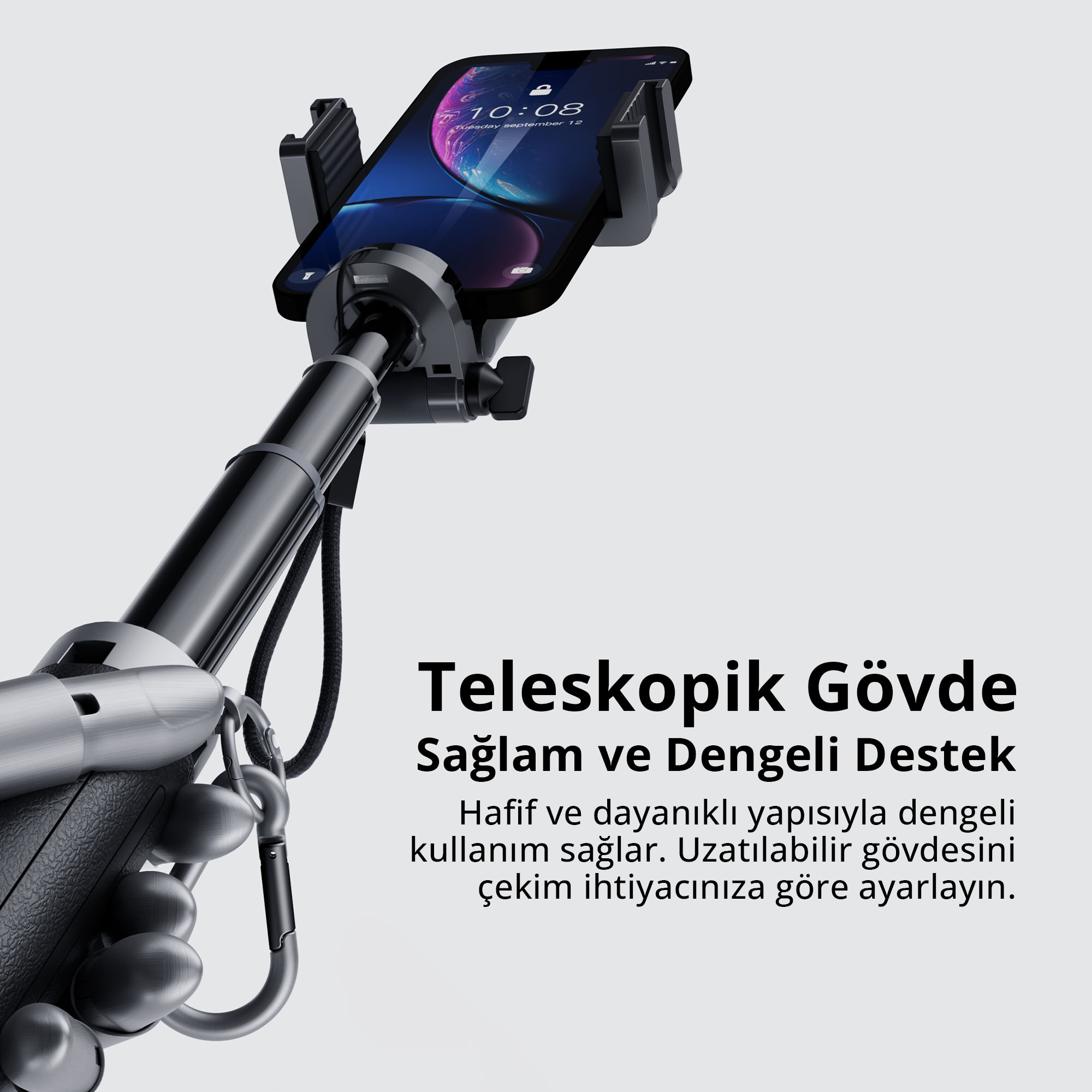 Gri arka planda köşede metin bulunan teleskopik çubuk üzerindeki tutucuda akıllı telefon.