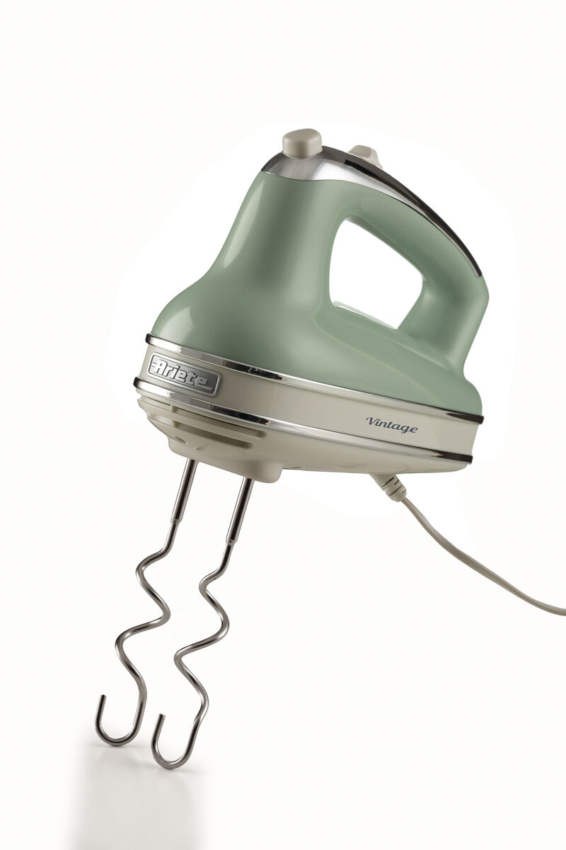 A pastel green vintage hand mixer with chrome accents and two dough hooks against a white background.