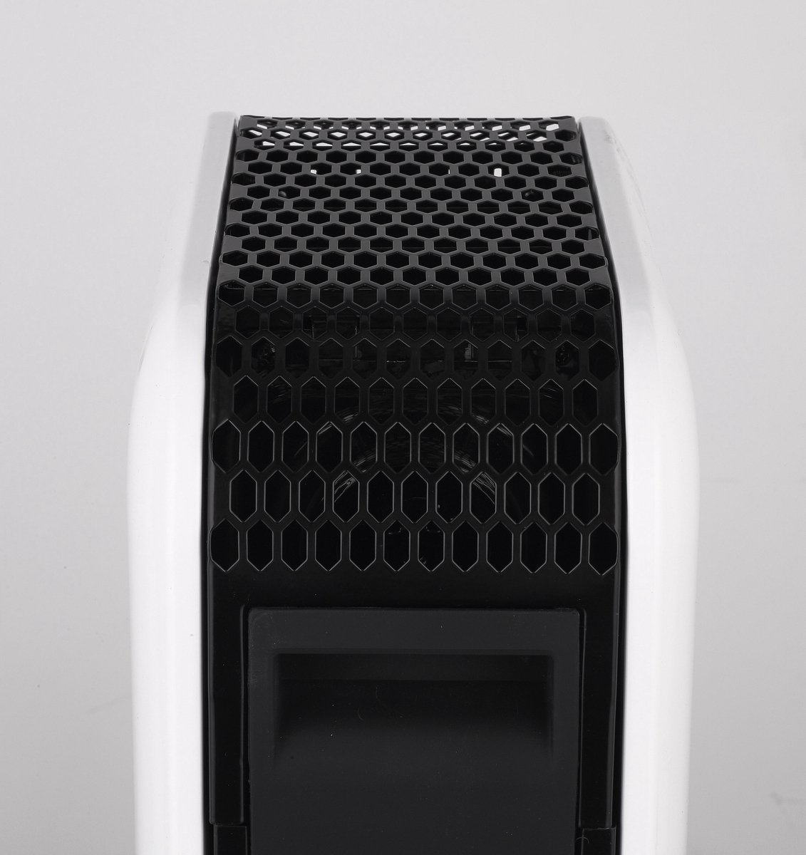 Un aparato blanco y negro con una rejilla con patrón de panal en la parte superior.