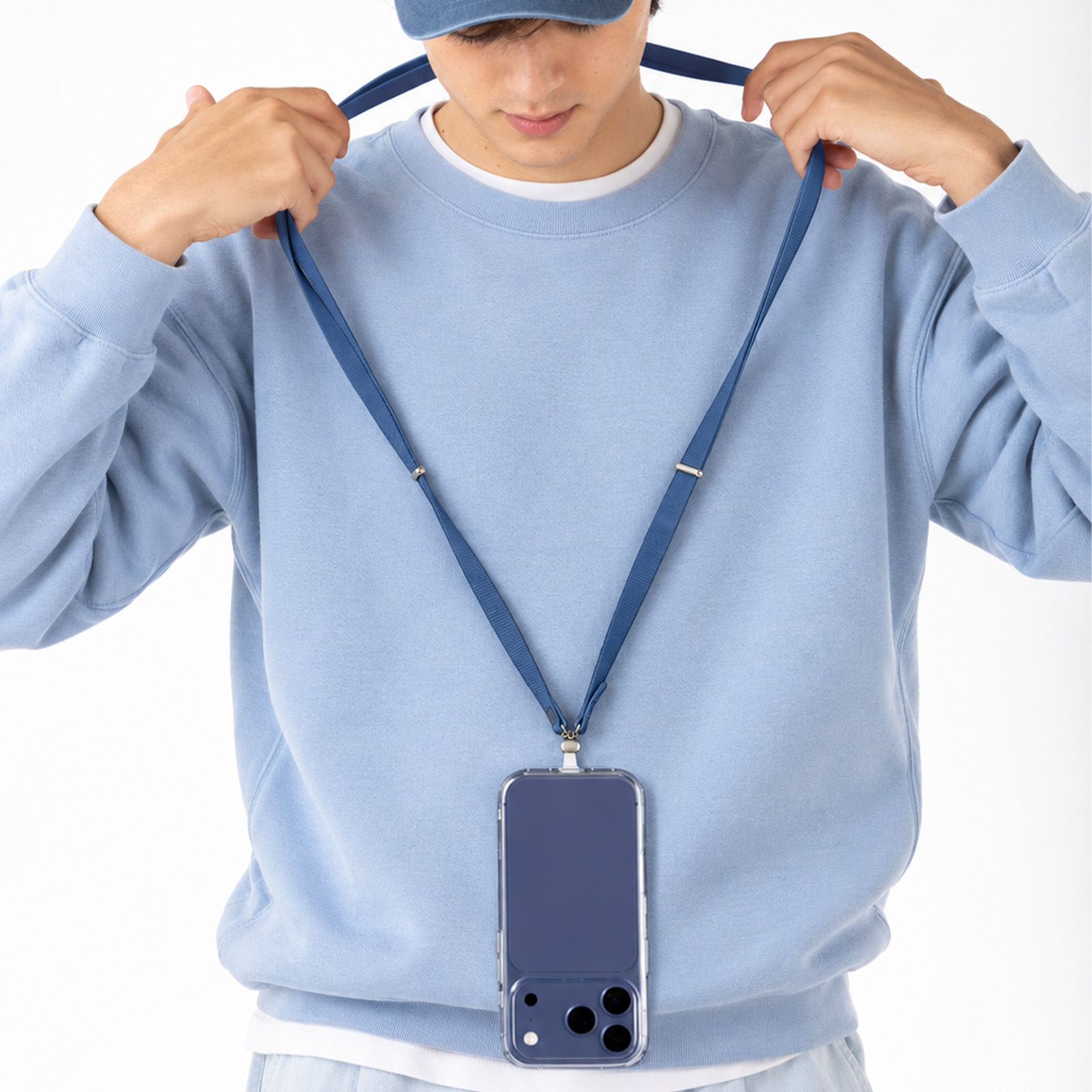 Un hombre con suéter celeste lleva un smartphone azul colgado al cuello con cordón.